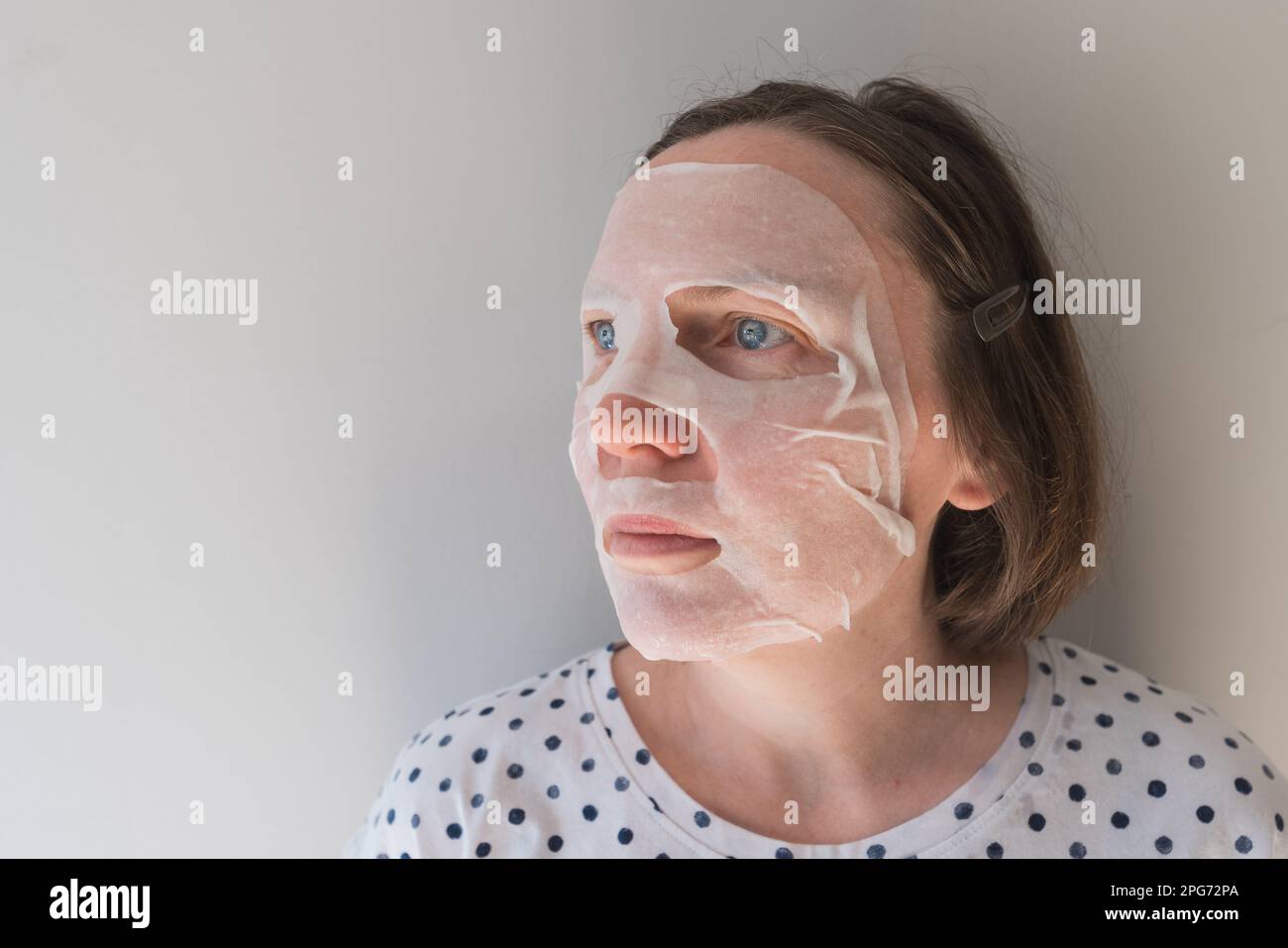 Erwachsene Kaukasierin mit Anti-Aging-Hydratationsblatt-Gesichtsmaske mit Hyaluron, selektiver Fokus Stockfoto