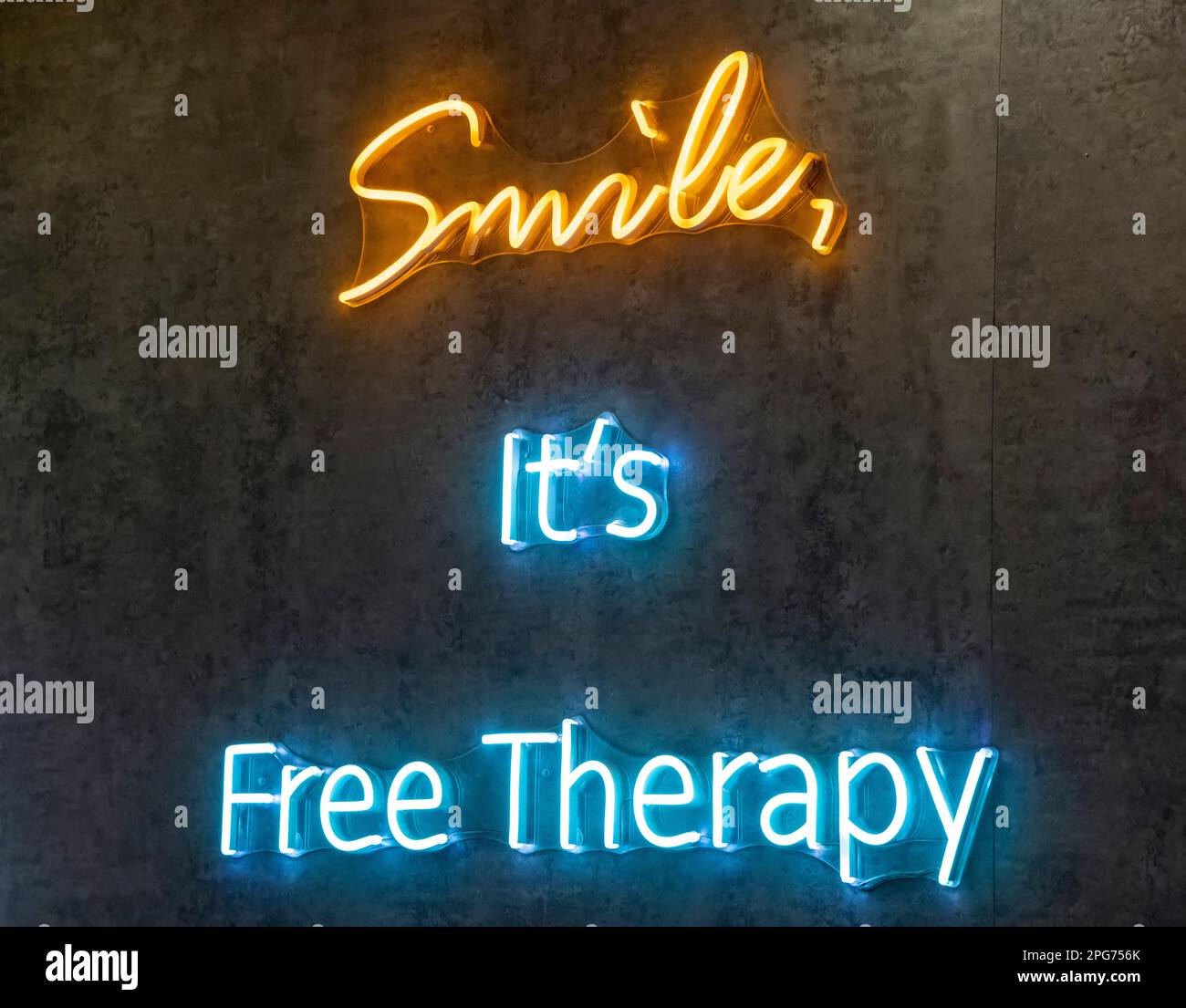 Neonschild mit „Smile it's free Therapy“, Hongkong, China. Stockfoto