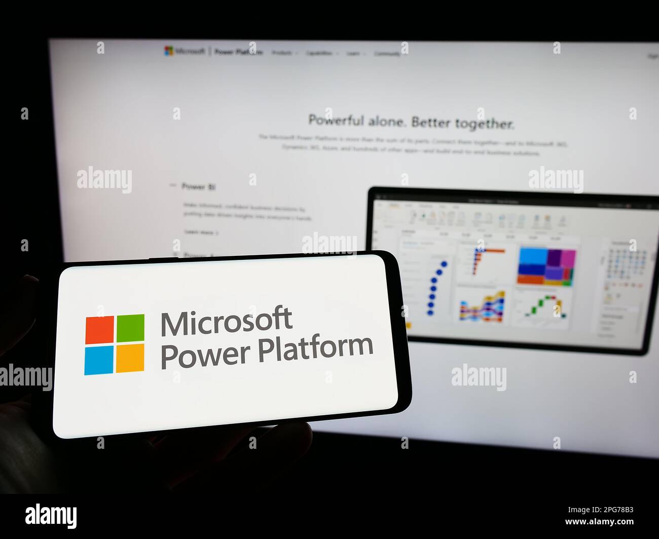 Person, die ein Mobiltelefon mit dem Logo der Softwareanwendung Microsoft Power Platform auf dem Bildschirm vor der Webseite hält. Konzentrieren Sie sich auf das Display des Telefons. Stockfoto