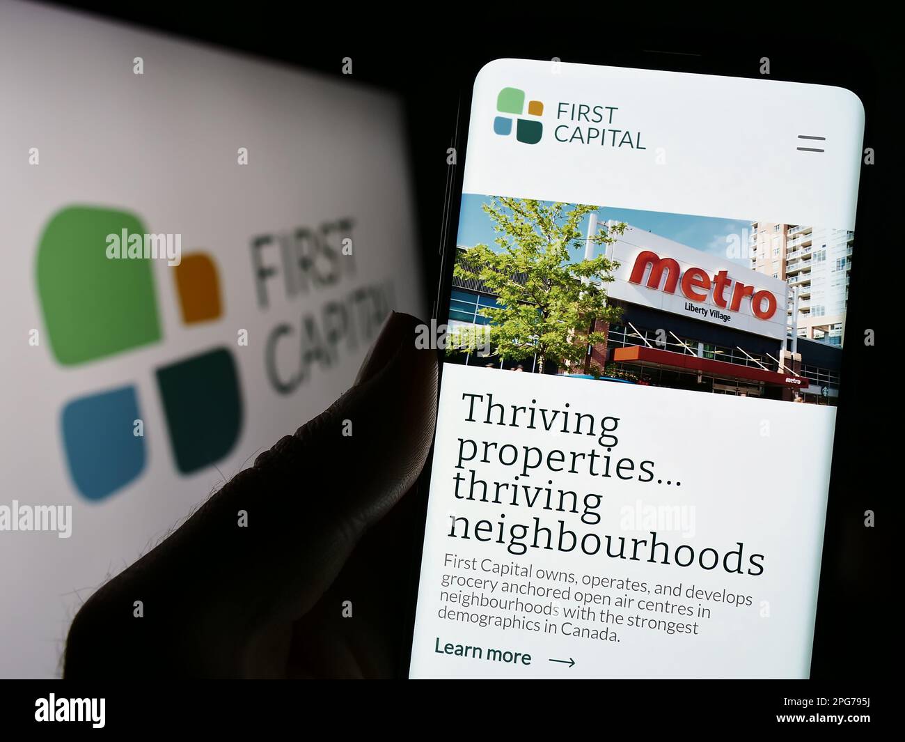 Person, die ein Mobiltelefon mit einer Website des kanadischen Immobilienunternehmens First Capital REIT auf dem Bildschirm mit Logo hält. Konzentrieren Sie sich auf die Mitte des Telefondisplays. Stockfoto