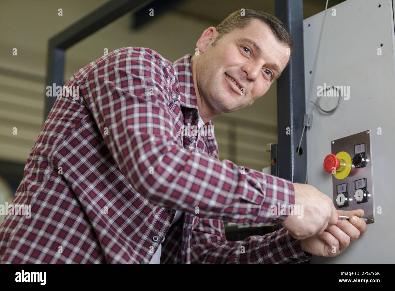 Mann, der die Maschine in einer Fabrik bedient Stockfoto