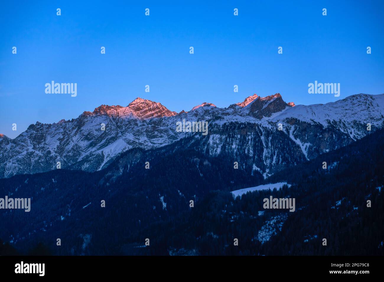 Sonnenuntergang, mit Gipfeln wie Muot la Seila (2.387 m) und Piz Sursass (2.910 m) in Orange/Pink, aus Guarda, Niederengadin, Schweiz Stockfoto