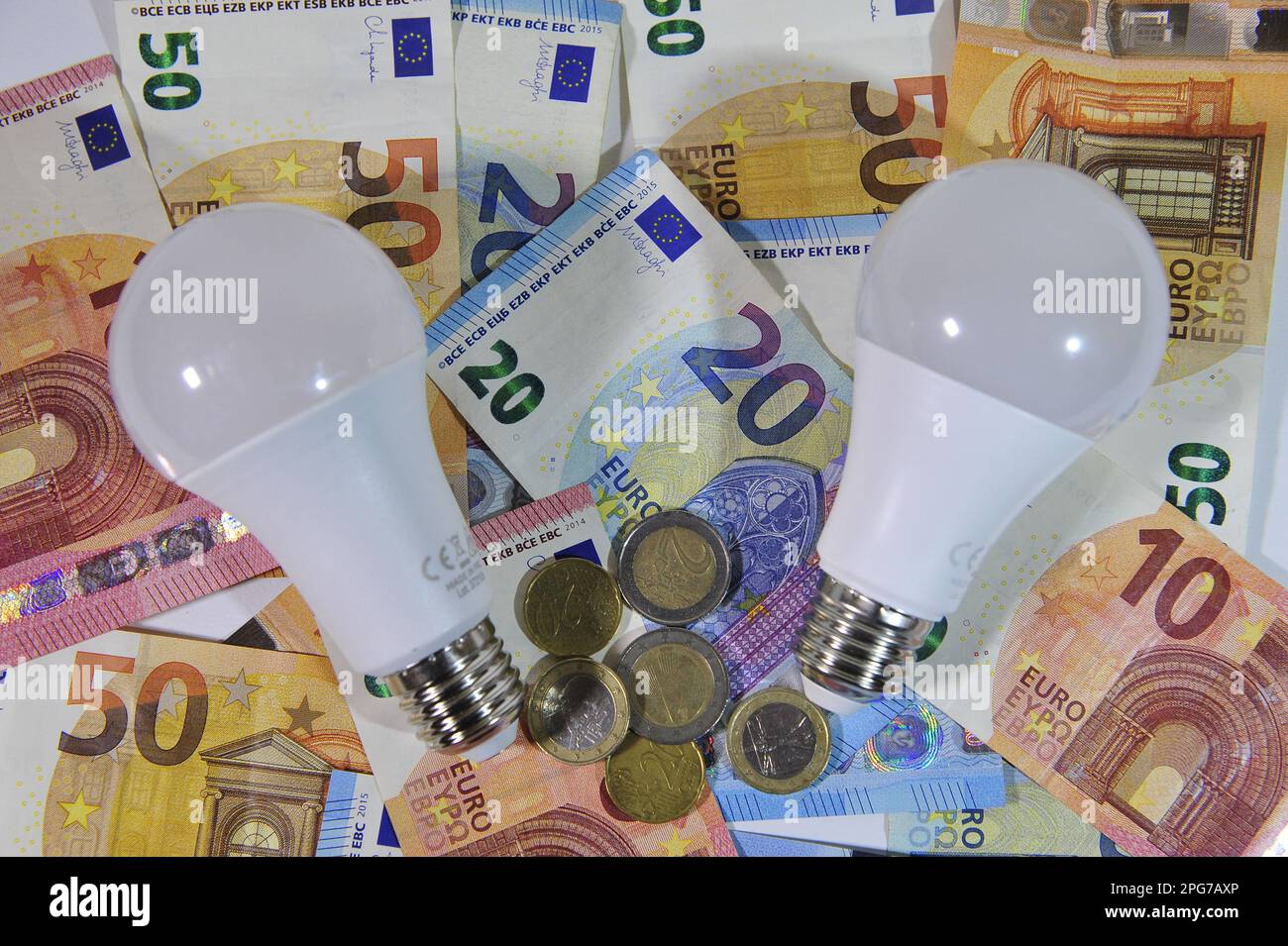 Der Strompreis, mit Geld und Glühbirne Stockfoto