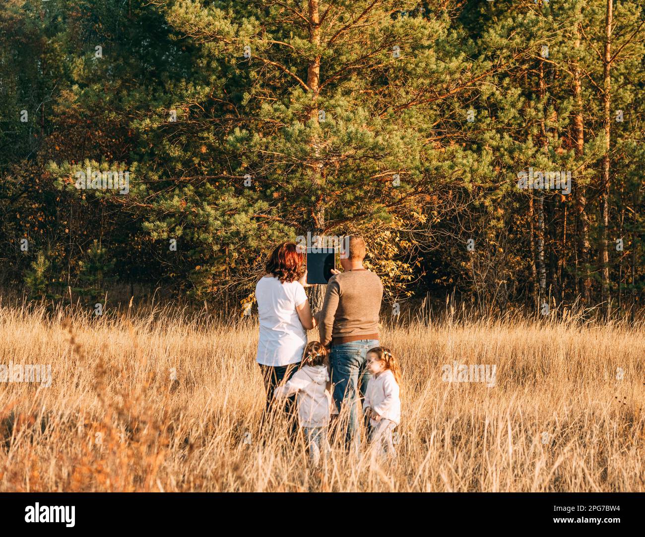 Ein junges Ehepaar mit Kindern plant, ein Haus auf einem Grundstück in der Nähe des Waldes zu bauen Stockfoto