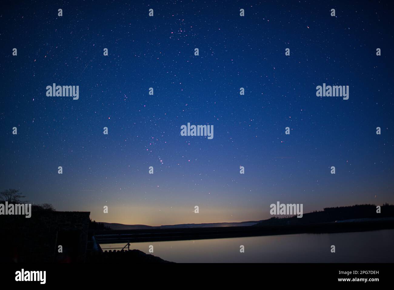 Kielder-Damm und Kielder-Wasser unter einem klaren Sternenhimmel, einschließlich Orion-Sternbild, Northumberland International Dark Sky Park Stockfoto