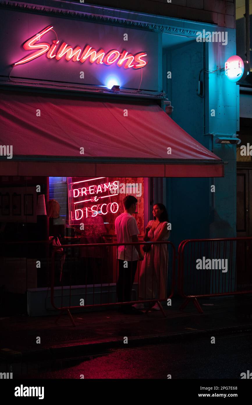 Eine romantische Nachtszene in Londons Soho vor dem Disco-Club und der Bar Simmons. Stockfoto