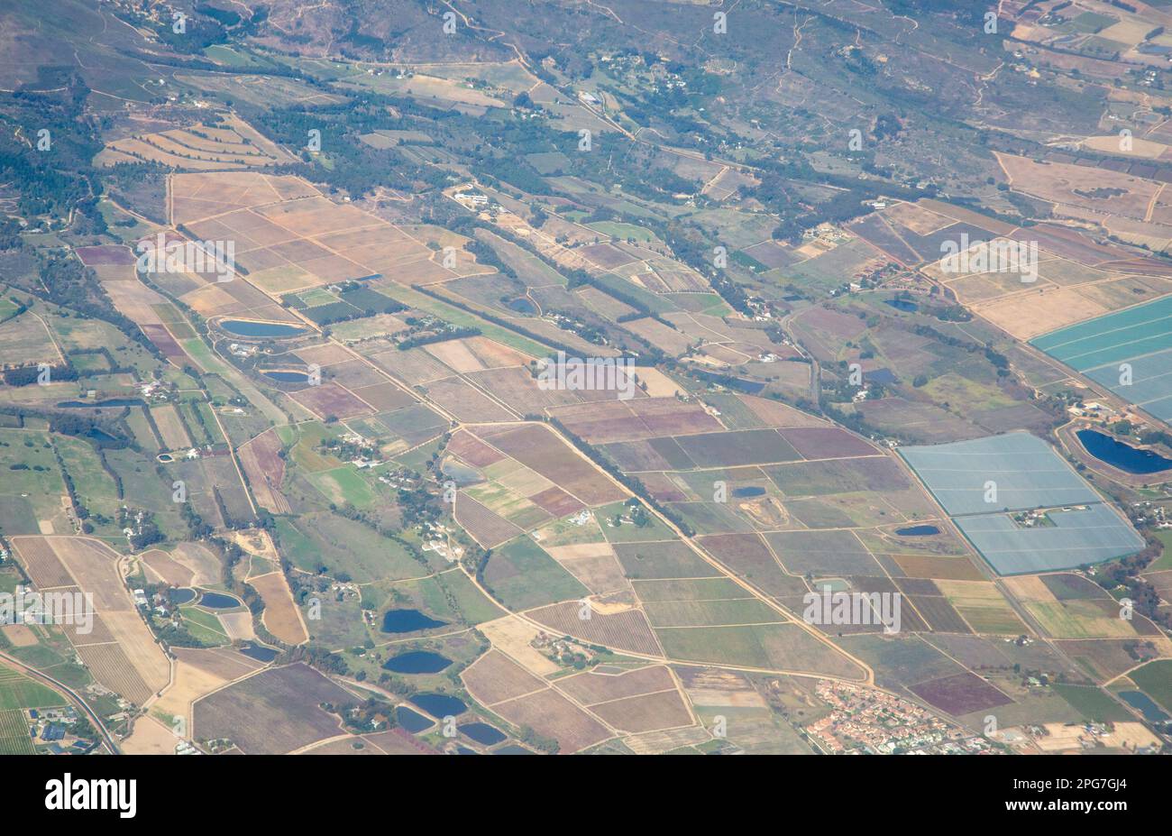 Flickenteppiche von Ackerland, Dämmen und schattenbedeckten intensiven Landwirtschaftsbetrieben im Westkap im Gebiet Stellenbosch/Paarl Stockfoto