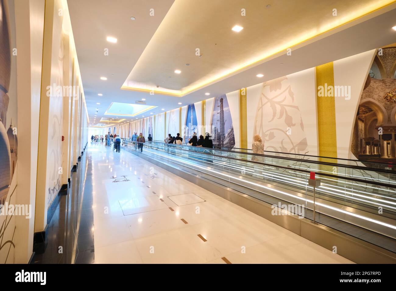 Der Fußweg und die sich bewegenden Gehwege entlang des langen, unterirdischen Korridors, über den Besucher die Anlage erreichen können. In der Scheich-Zayid-Moschee in Abu Dhabi Stockfoto