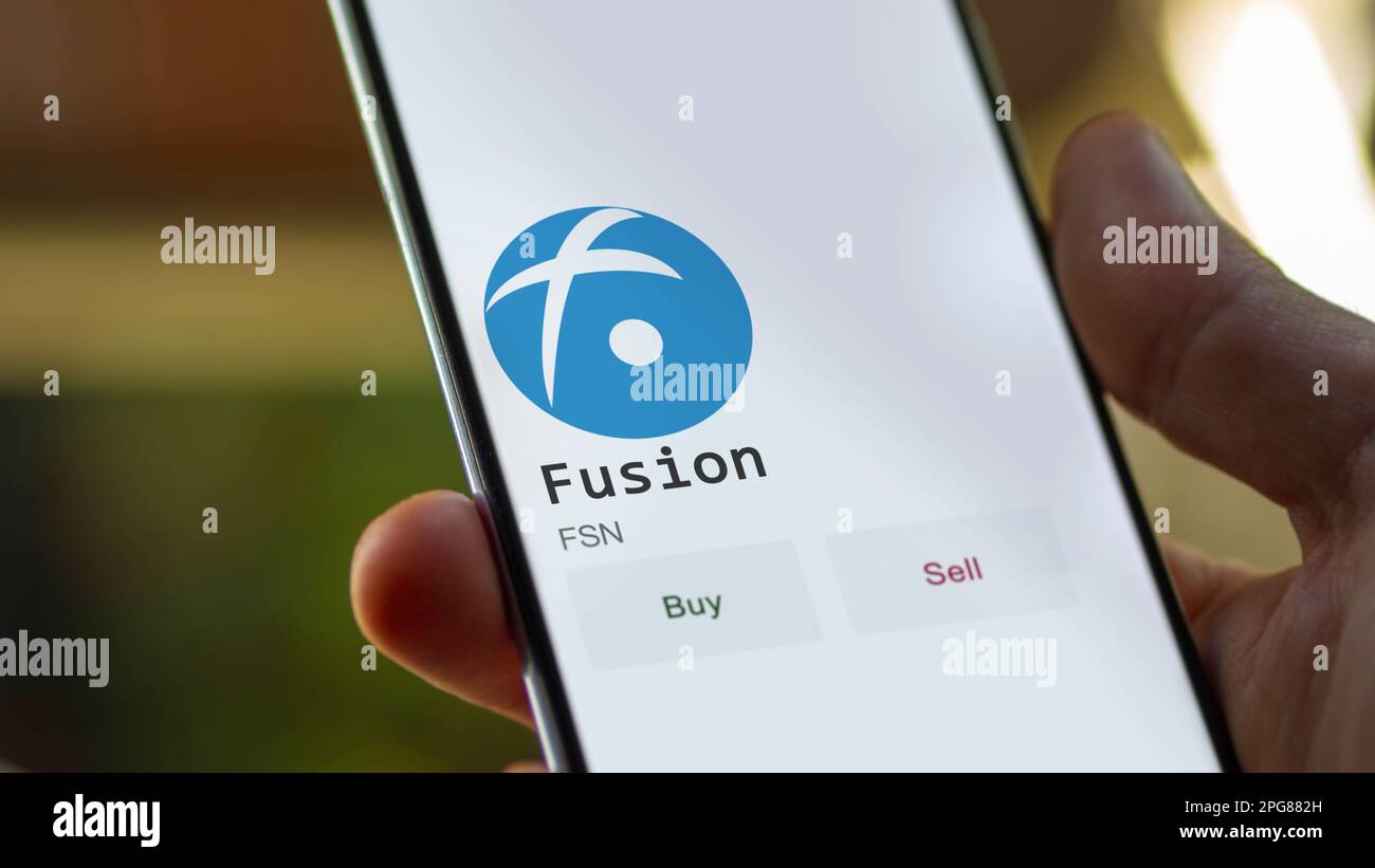 März 11 2023 London UK. Ein Investor analysiert die Fusion-Münze auf der Leinwand. Ein Telefon zeigt die Preise der ETF für Investitionen in FSN an Stockfoto