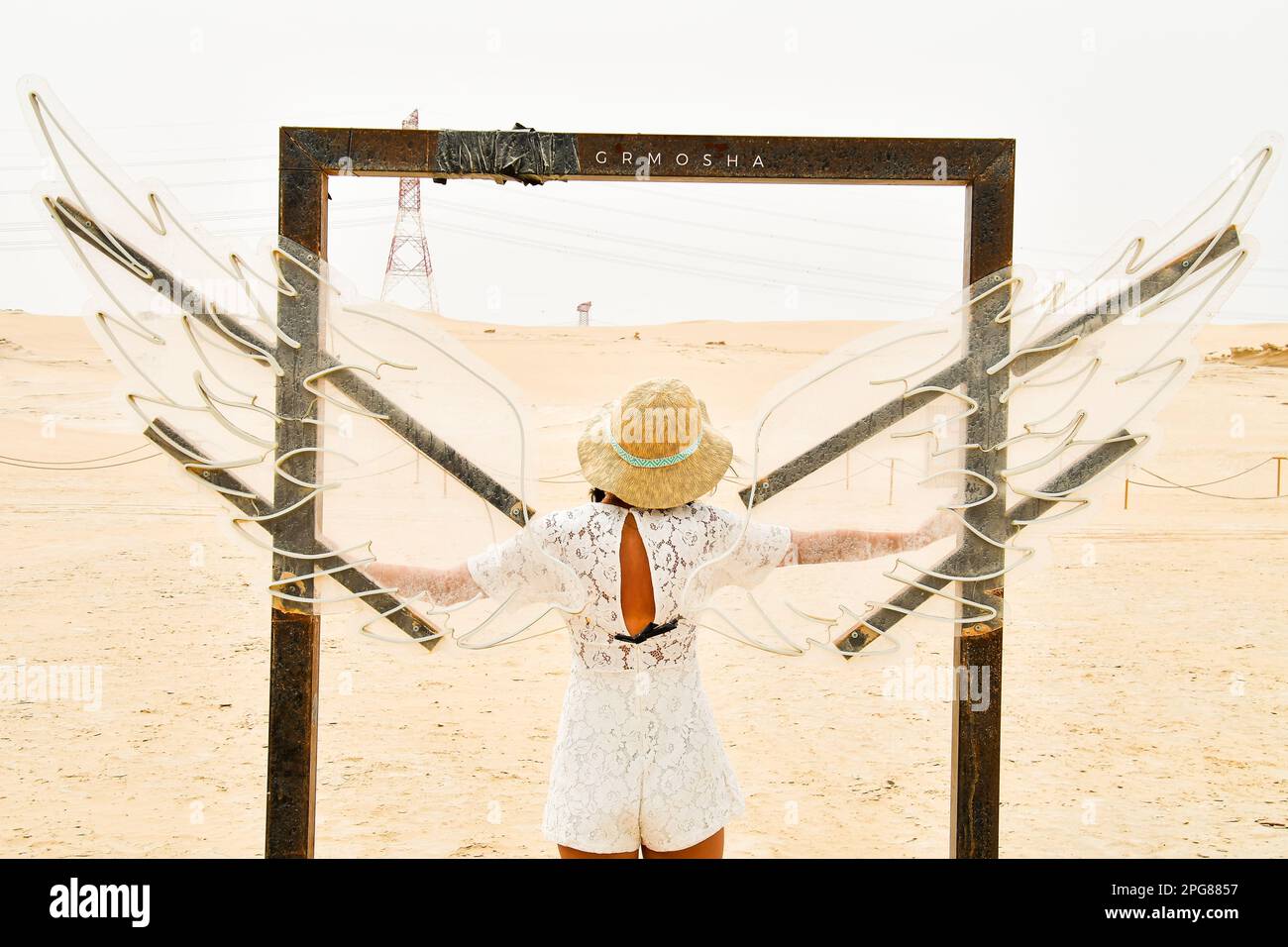 Abu Dhabi, Vereinigte Arabische Emirate - 15. märz 2023: Weibliche Touristen stehen mit Flügeln in Abu Dhabi, Vereinigte Arabische Emirate. Berühmtes Reiseziel außerhalb der Hauptstadt Stockfoto