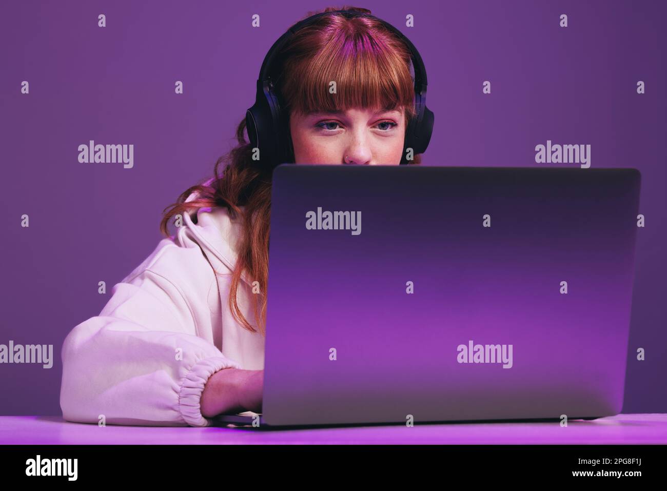 Eine Gamer-Frau schaute auf ihren Laptop-Bildschirm, während sie ein Online-Videospiel in einem Studio spielte. Frau, die einen interaktiven Streaming-Dienst nutzt. Stockfoto