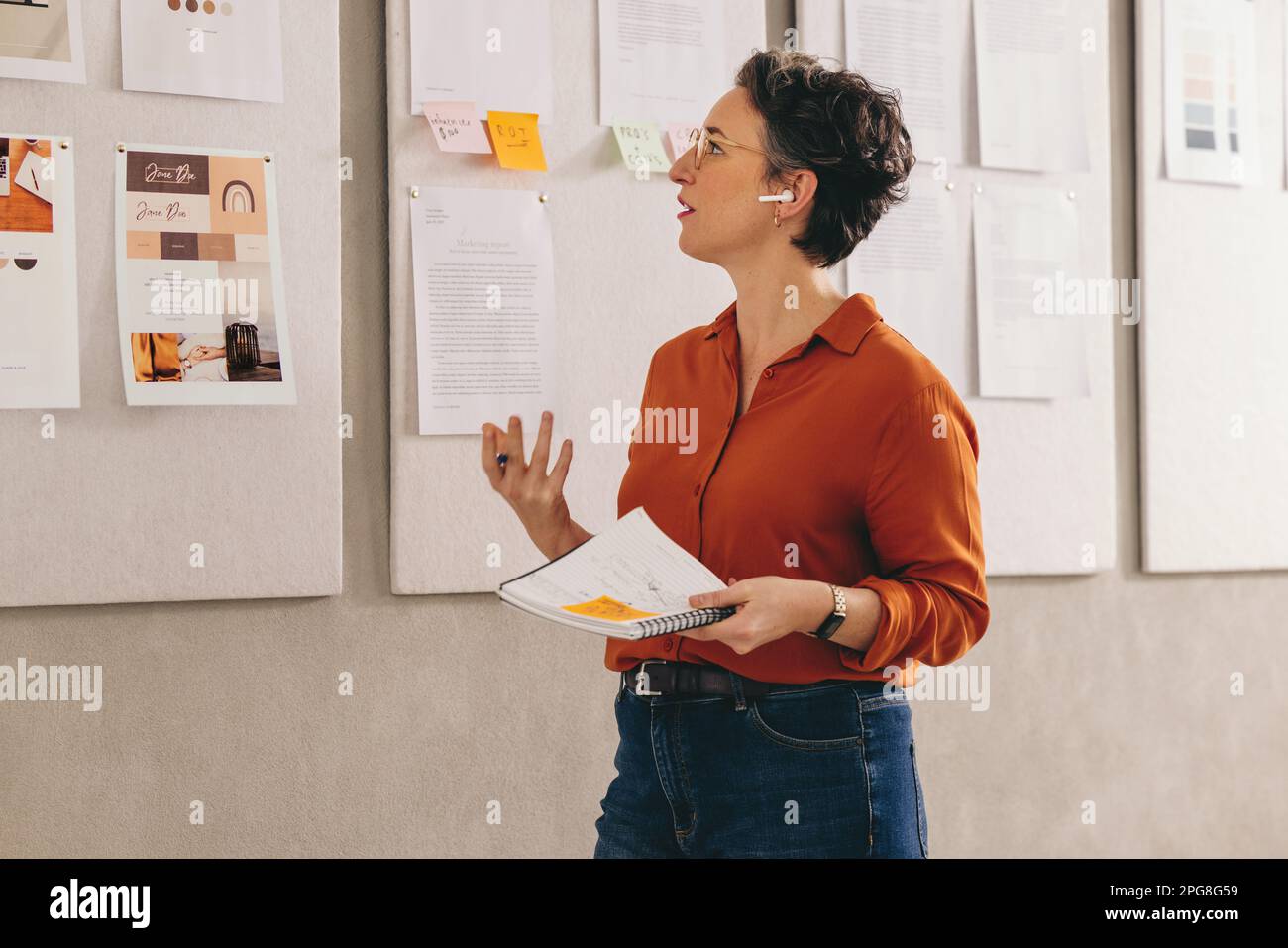 Reife Geschäftsfrau, die ihre Idee während einer Online-Telefonkonferenz ihrem Team vorstellt. Kreative Designerin präsentiert ihren Plan in einem virtuellen Meeting. Matur Stockfoto