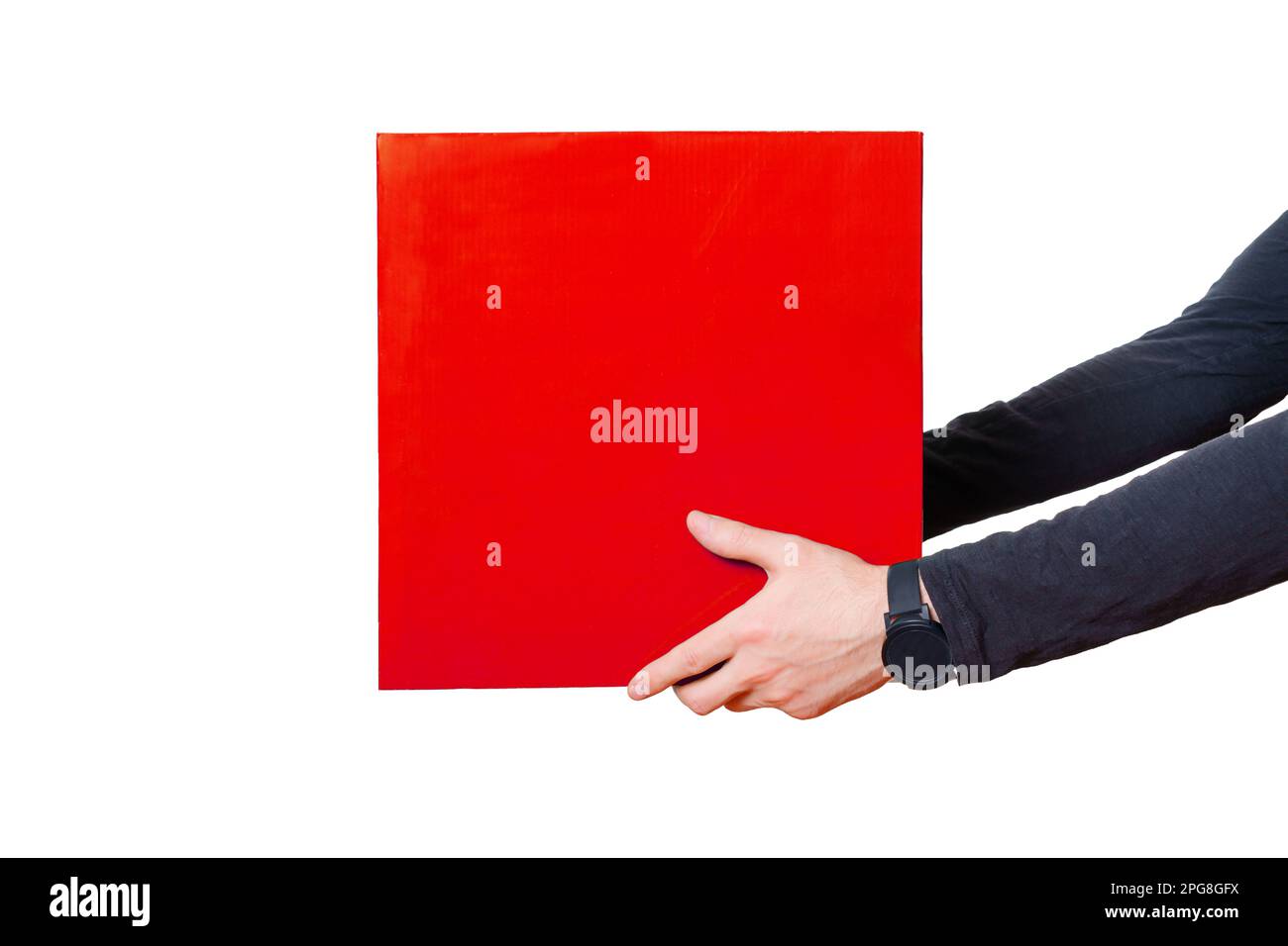 Ein Paar Hände, die ein schwarzes Langarmhemd tragen, halten eine große rote Box isoliert auf weiß. Mutige und moderne Lieferservices, E-Commerce und Logistik Stockfoto