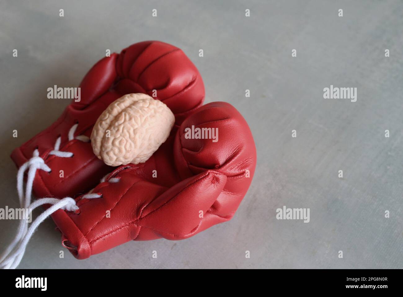 Menschliches Hirnmodell auf Boxhandschuhen mit Kopierraum. Das Konzept der Bekämpfung von Hirnkrankheiten Stockfoto