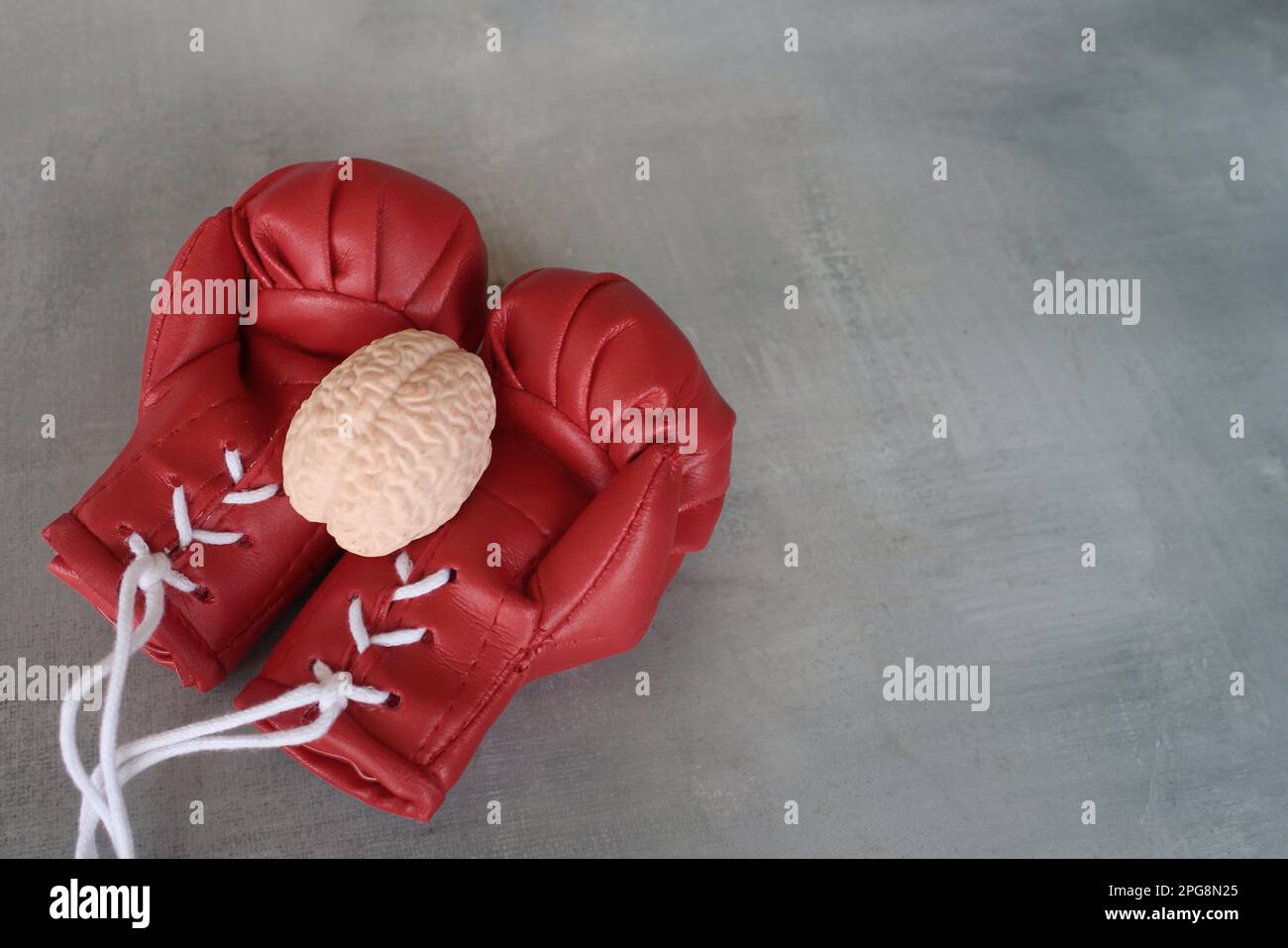 Menschliches Hirnmodell auf Boxhandschuhen mit Kopierraum. Das Konzept der Bekämpfung von Hirnkrankheiten Stockfoto