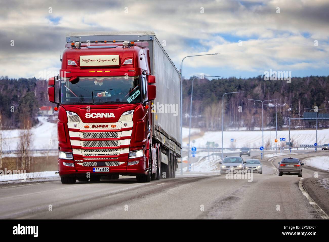 Der personalisierte rote Scania 500 S Super Truck zieht einen Auflieger im Verkehr an einem Wintertag. Salo, Finnland. 11. März 2023. Stockfoto