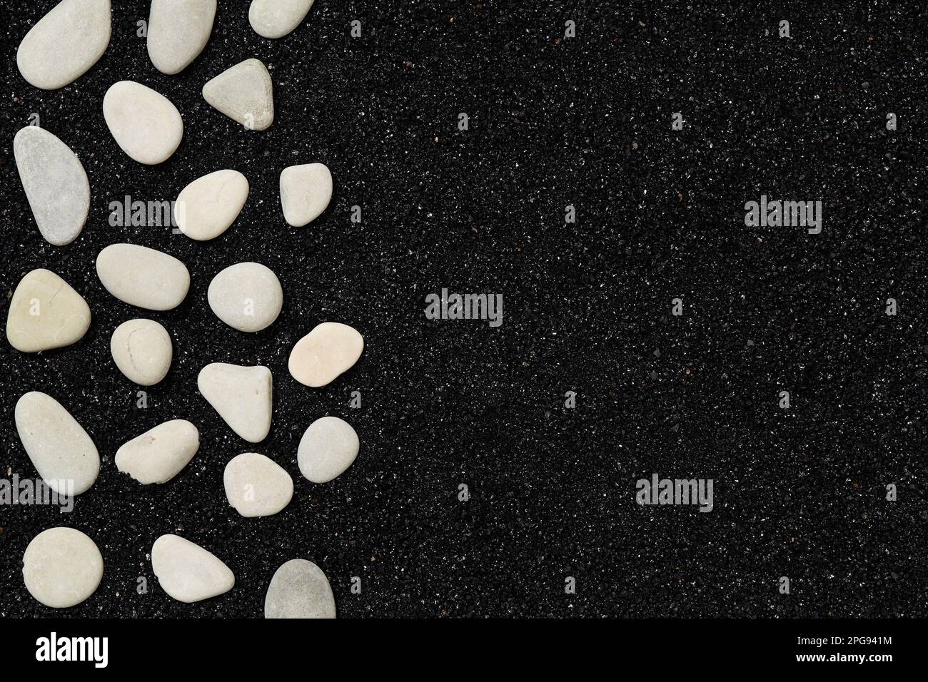 Schwarzer Sand mit Kieseln. Strandhintergrund mit Platz für Ihren eigenen Text Stockfoto