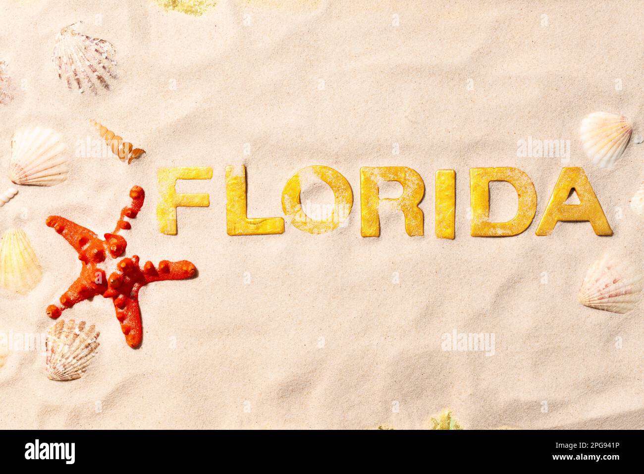 Florida - Text in weißem Sand mit Muscheln und Seesternen. Strandurlaubskonzept Stockfoto