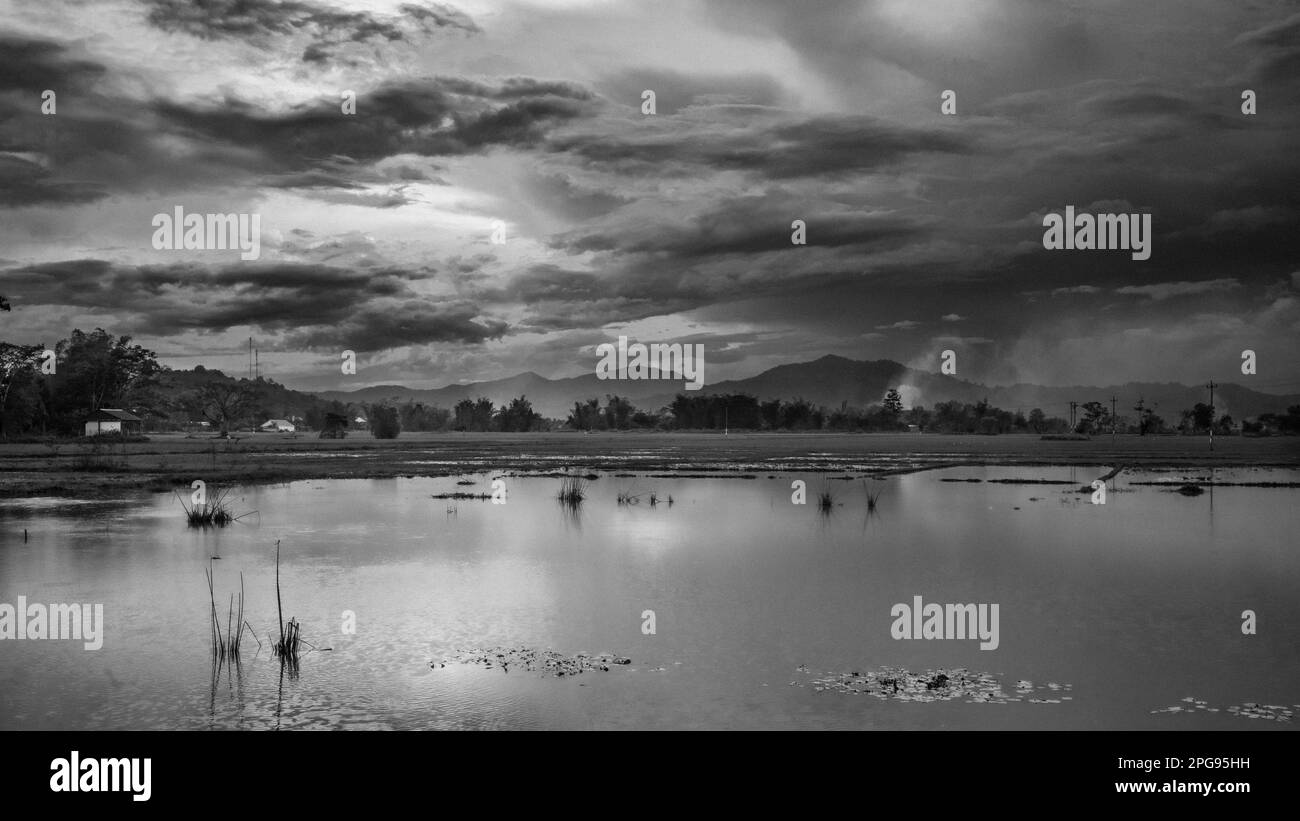 Blick über einen See in Richtung Berge im ethnischen Minderheitendorf Buon Jun M'nong in Lien Son, Vietnam. Stockfoto