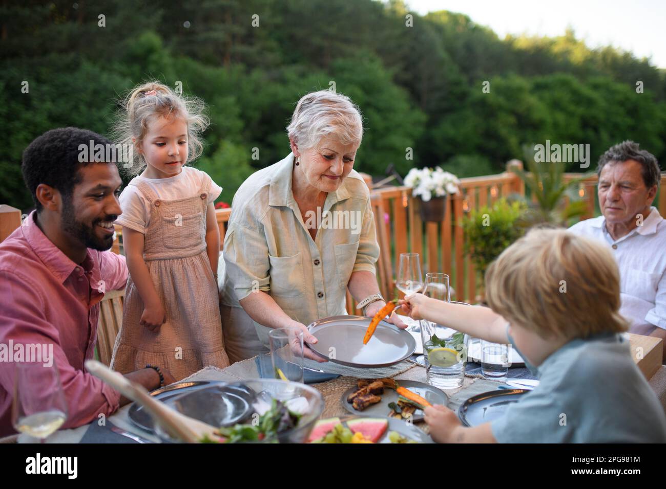 Eine Familie mehrerer Generationen isst auf einer Barbecue-Party zu Abend. Stockfoto