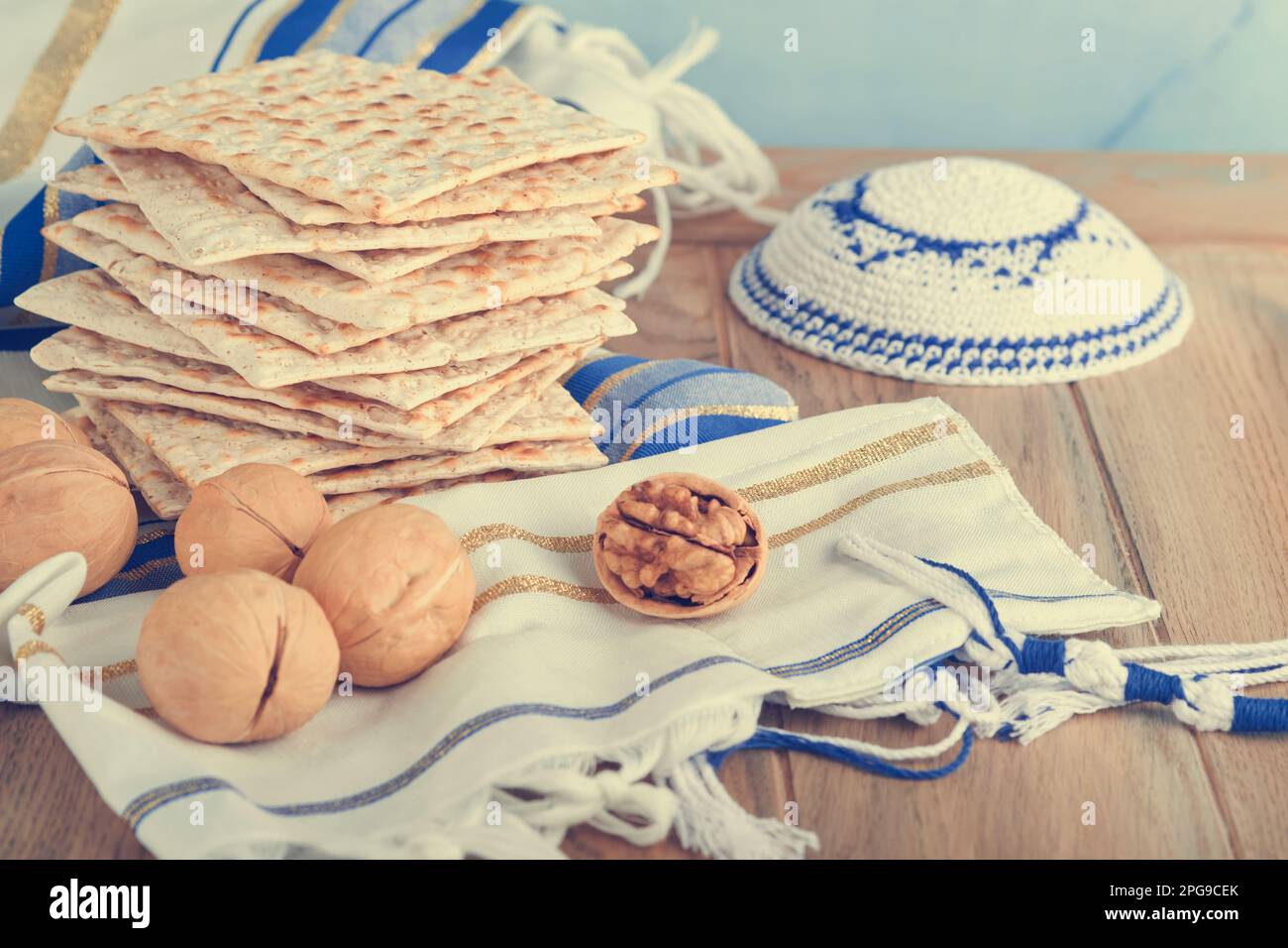 Das Konzept der Pessachstunde. Matzah, roter Koscher und Walnuss. Traditionelles jüdisches Brot Matzah, Kippah und Tallit auf altem Holzhintergrund. Passo Stockfoto