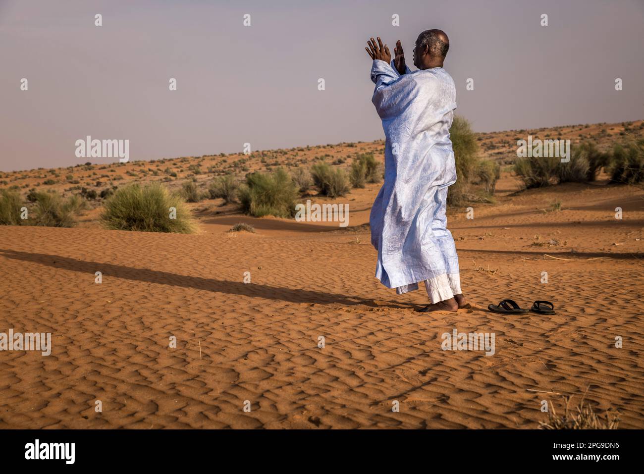 Brahim Ramdhane, ehemaliger Sklave und Gründer seiner NGO Sahel Fondation, hier in Sunite Gebete in der Wüste zwischen Nouakshott und seiner Heimatstadt Boutilimit in Mauretanien, wo er als Sklave aufwuchs. Er kämpft gegen die Sklaverei, gegen die Unterdrückung seines Haratin-Stammes und für faire Bildungsmöglichkeiten, seit er sich als Teenager befreit hat. Stockfoto