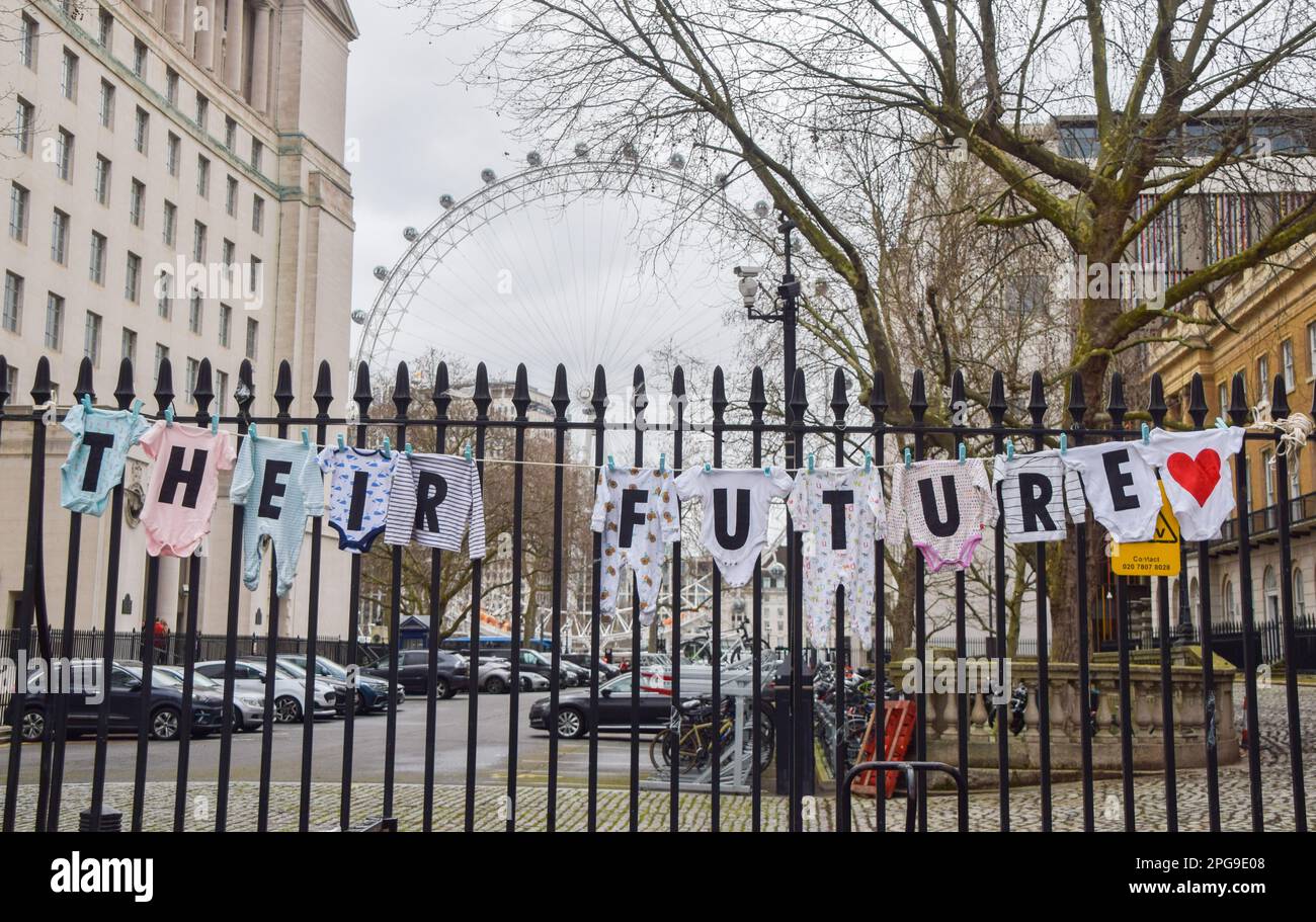 London, Großbritannien. 21. März 2023. Babykleidung mit Buchstaben, die „ihre Zukunft“ ausdrücken, wird während des Protests gesehen. 10 Mütter veranstalten einen Hungerstreik außerhalb der Downing Street für sechs Tage in Solidarität mit den Millionen Müttern im Vereinigten Königreich, die aufgrund der Krise der Lebenshaltungskosten gezwungen sind, auf Mahlzeiten zu verzichten, um ihre Kinder zu ernähren. Und Mütter weltweit, deren Kinder aufgrund der Klimakrise unter starkem Hunger und Unterernährung leiden. Kredit: SOPA Images Limited/Alamy Live News Stockfoto