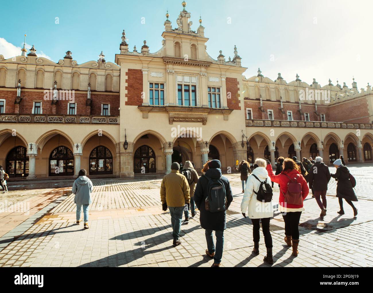 Krakau, Polen - 6. märz 2023: Reiseleiter mit Reisegruppe auf dem Hauptplatz in Krakau. Kostenlose Touristenwanderungen mit Einheimischen. Einzigartiges Erlebnis in New Cit Stockfoto