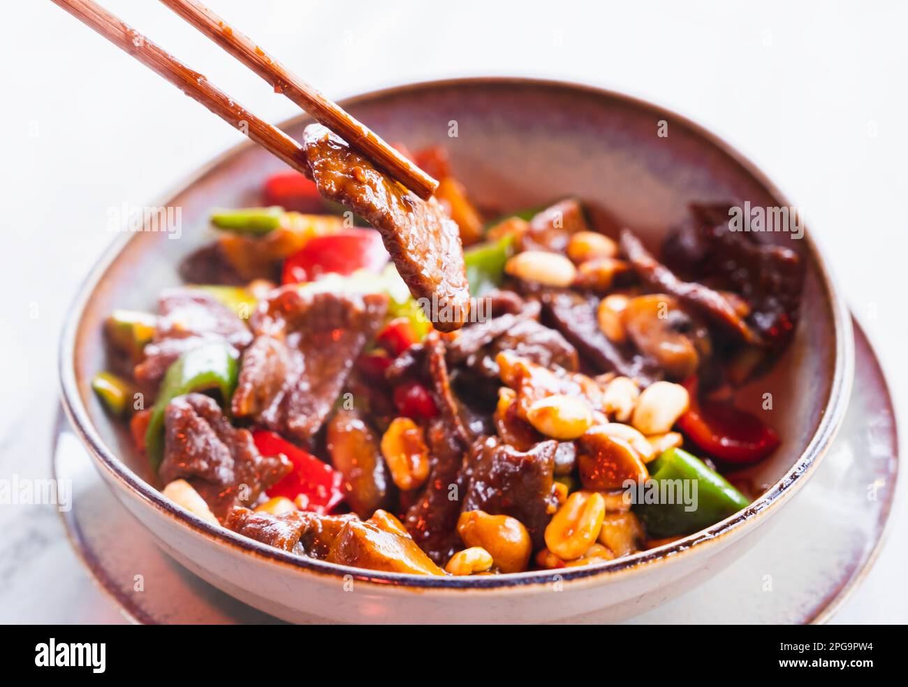 Gebratenes chinesisches Gericht mit gewürfeltem Rindfleisch, Gemüse und Erdnüssen in einem Topf. Stockfoto