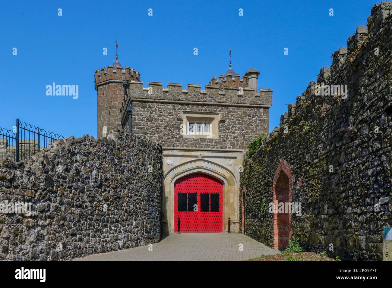 Altstadt Mauern zur Barbican Gate Lodge ein Neo-Tudor Gebäude mit Doppeltürmen und Tudor Bogen in Antrim Nordirland UK an einem sonnigen Tag mit blauem Himmel. Stockfoto