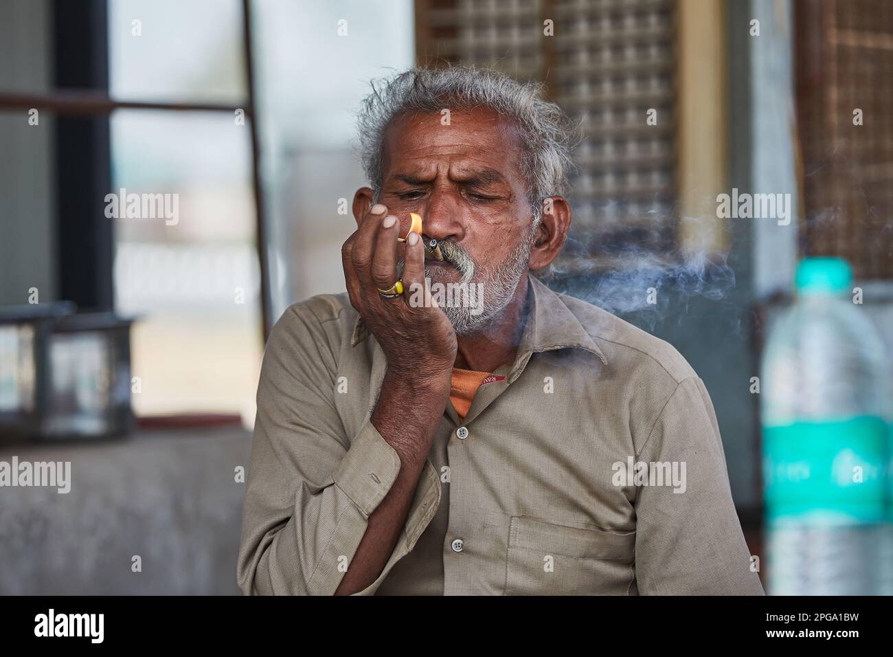 Delhi, Indien - Portrai eines älteren Indianers, der eine Biene anzündet Stockfoto