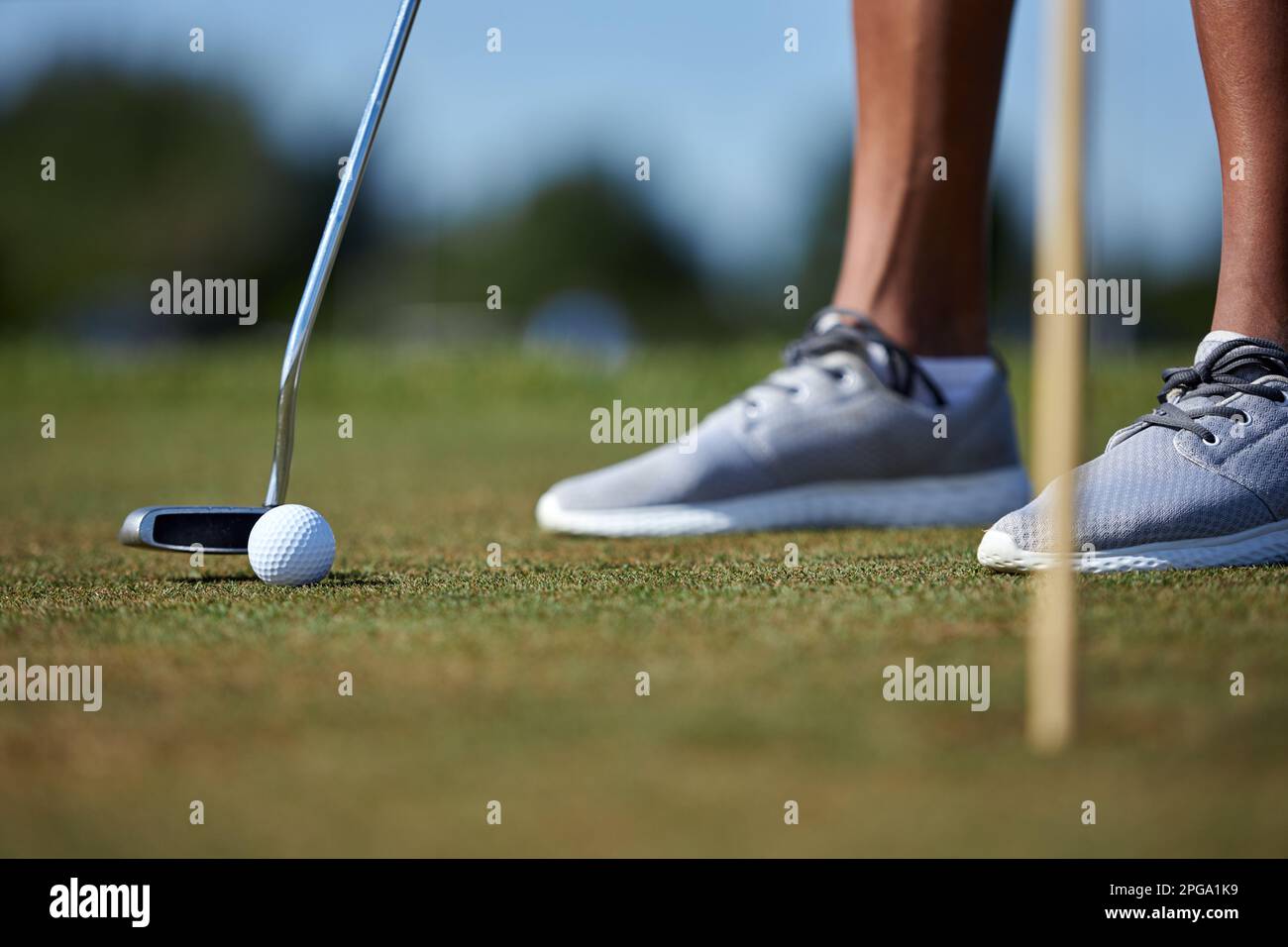 Nahaufnahme einer nicht wiedererkennbaren Person, die Golf spielt, mit Fokus auf Golfschläger, Ball auf Gras, Kopierraum Stockfoto