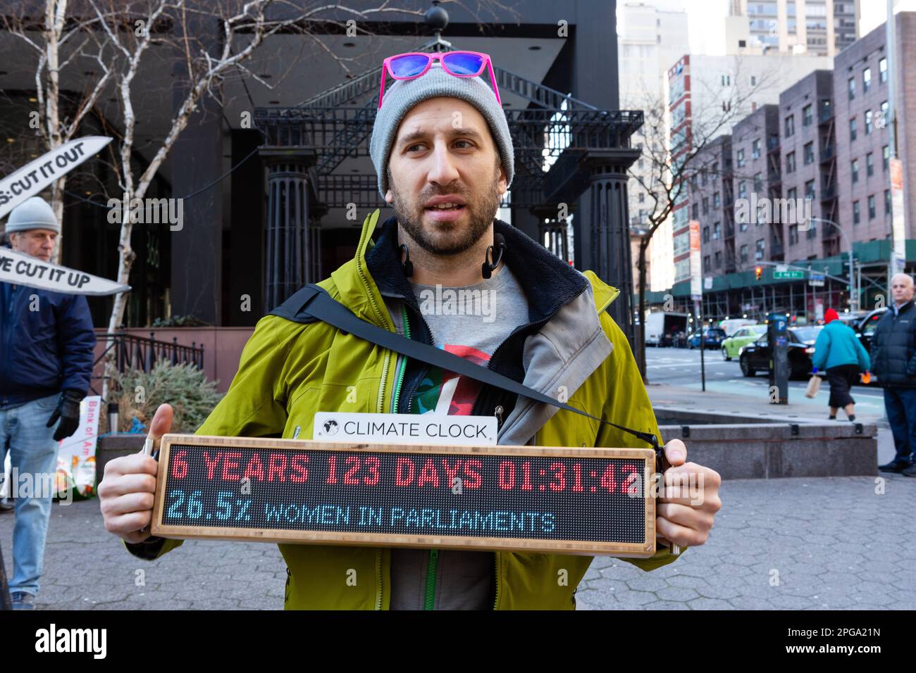 New York, New York, USA. 21. März 2023. Dritter Akt, die soziale Aktivistenbewegung älterer Menschen, sponserte eine Kundgebung gegen Bankinvestitionen in fossile Brennstoffe, die am Dag Hammerskjöld Plaza begann und in die 47. Straße zum Hauptsitz von J. P. Morgan Chase zog. Ein Mann hat eine digitale Klimauhr, die 6 Jahre, 123 Tage, 1 Stunde, 31 Minuten und 42 Sekunden anzeigt. Kredit: Ed Lefkowicz/Alamy Live News Stockfoto