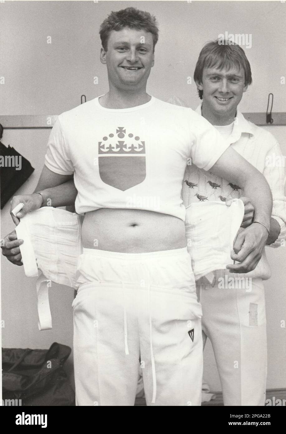 NEUSEELAND UND SUSSEX CRICKETSPIELER ADRIAN JONES HELFEN TEAMKOLLEGE TONY PIGGOTT, UM SEINE RÜCKENBÄNDER, 1986, ANZUBRINGEN. BILD MIKE WALKER, 1986 Stockfoto