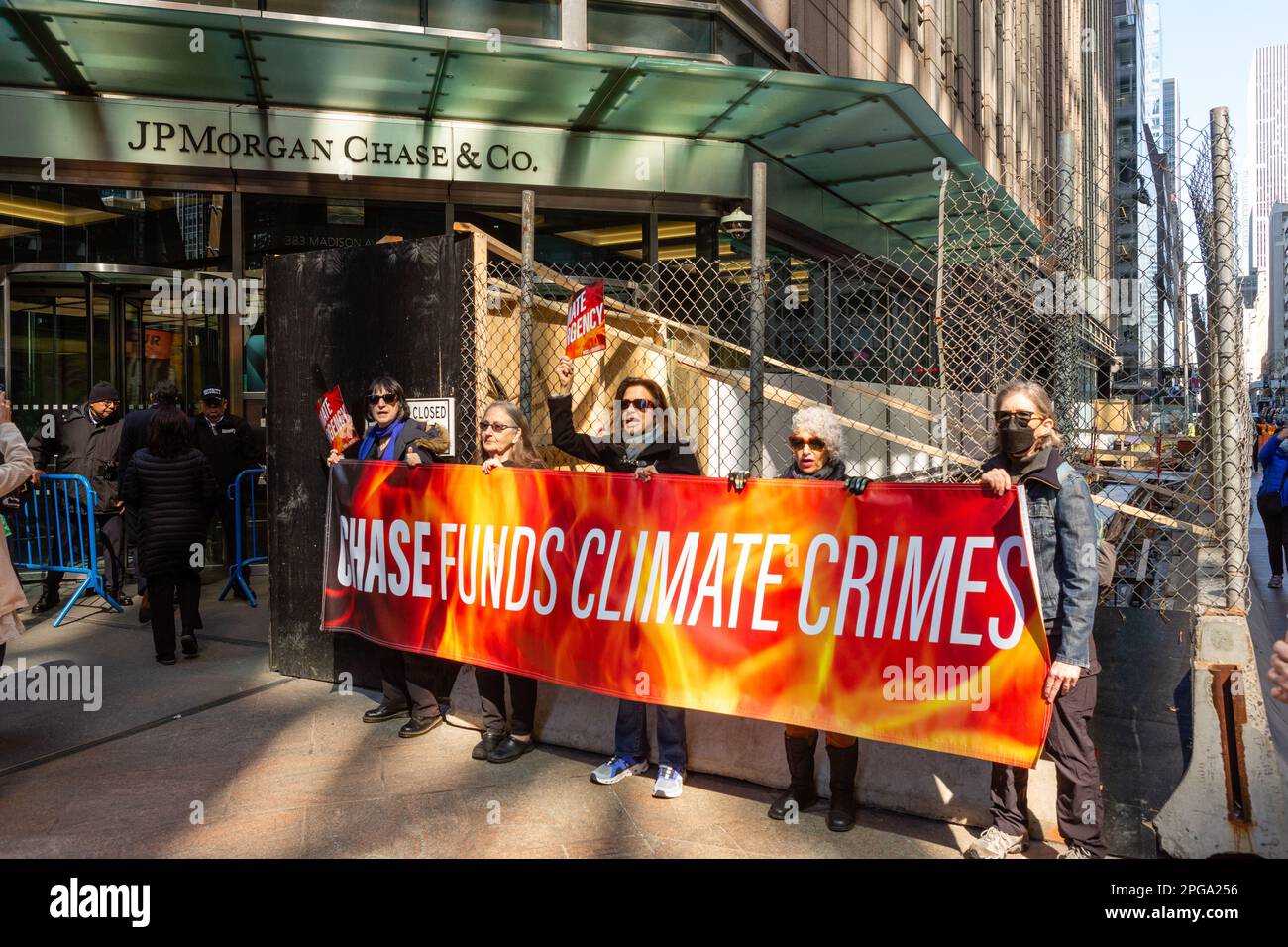 New York, New York, USA. 21. März 2023. Dritter Akt, die soziale Aktivistenbewegung älterer Menschen, sponserte eine Kundgebung gegen Bankinvestitionen in fossile Brennstoffe, die am Dag Hammerskjöld Plaza begann und in die 47. Straße zum Hauptsitz von J. P. Morgan Chase zog. Demonstranten halten ein Schild mit der Aufschrift "Chase Funds Climate Crimes" vor dem Eingang zur Bank. Kredit: Ed Lefkowicz/Alamy Live News Stockfoto