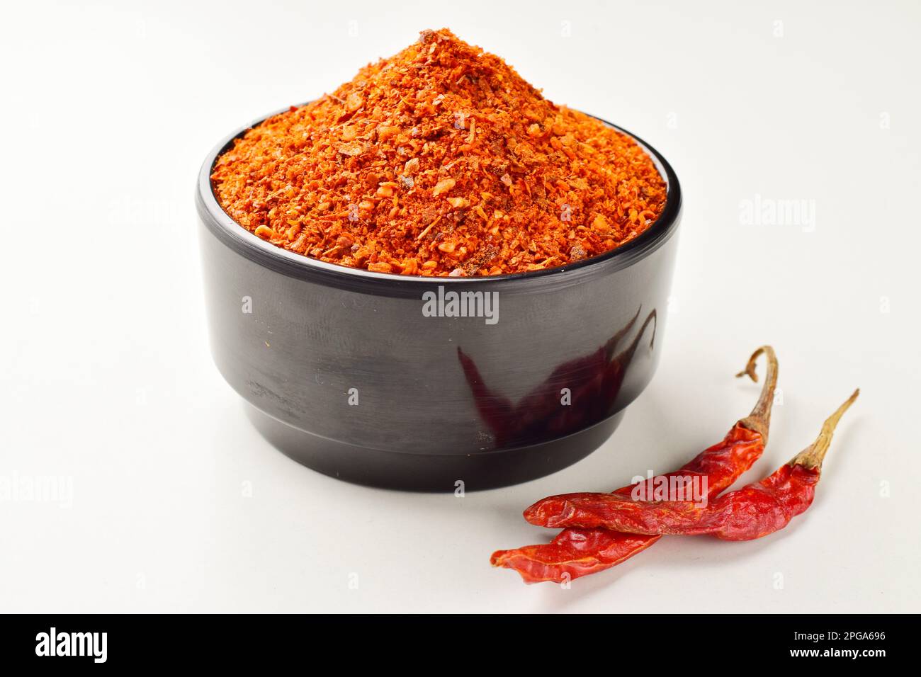 Chilipulver isoliert auf weißem Hintergrund, würzige Zutaten Stockfoto