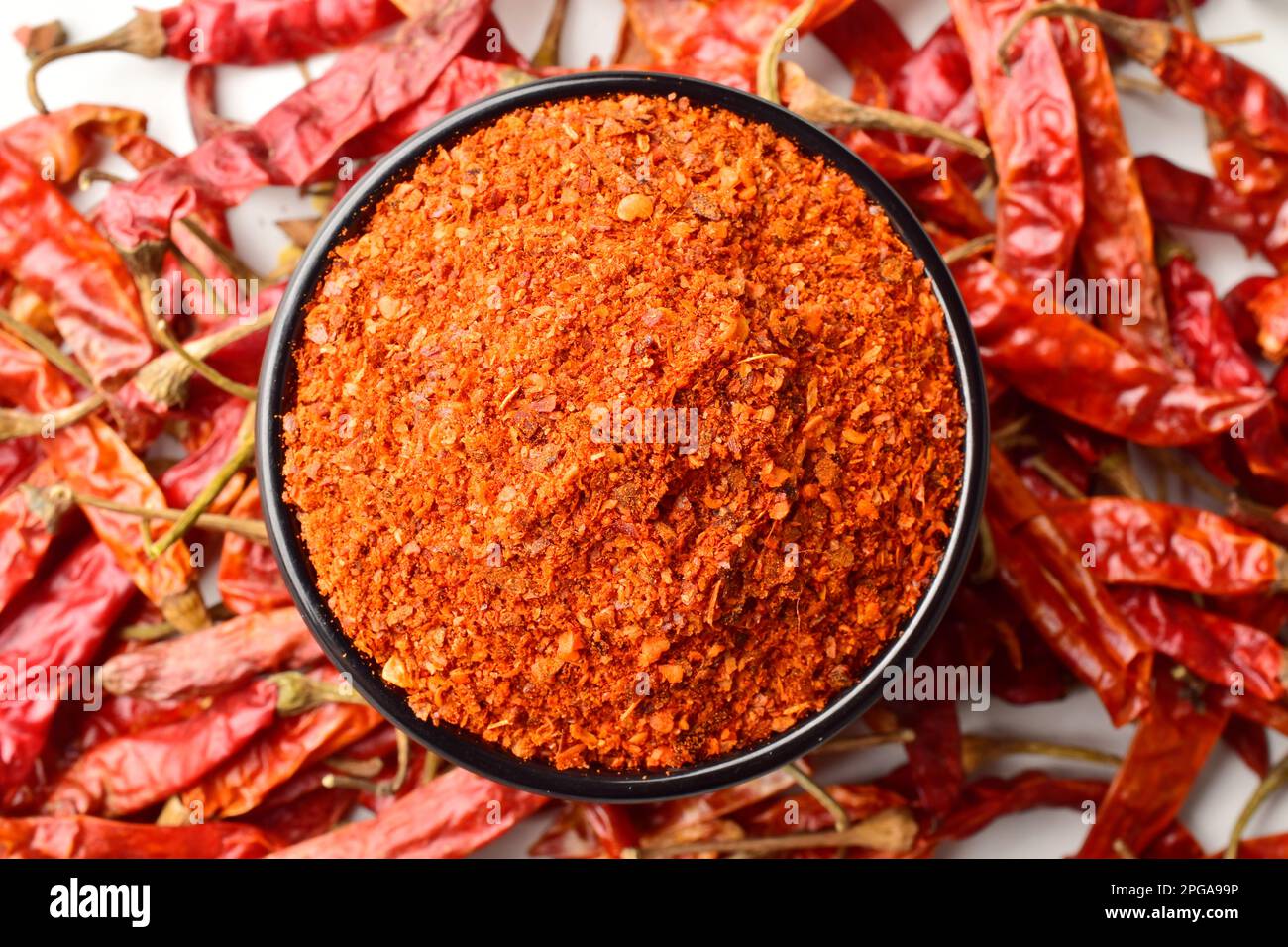 Blick von oben auf gemahlenes rotes Chili mit trockenen Chilischoten Stockfoto