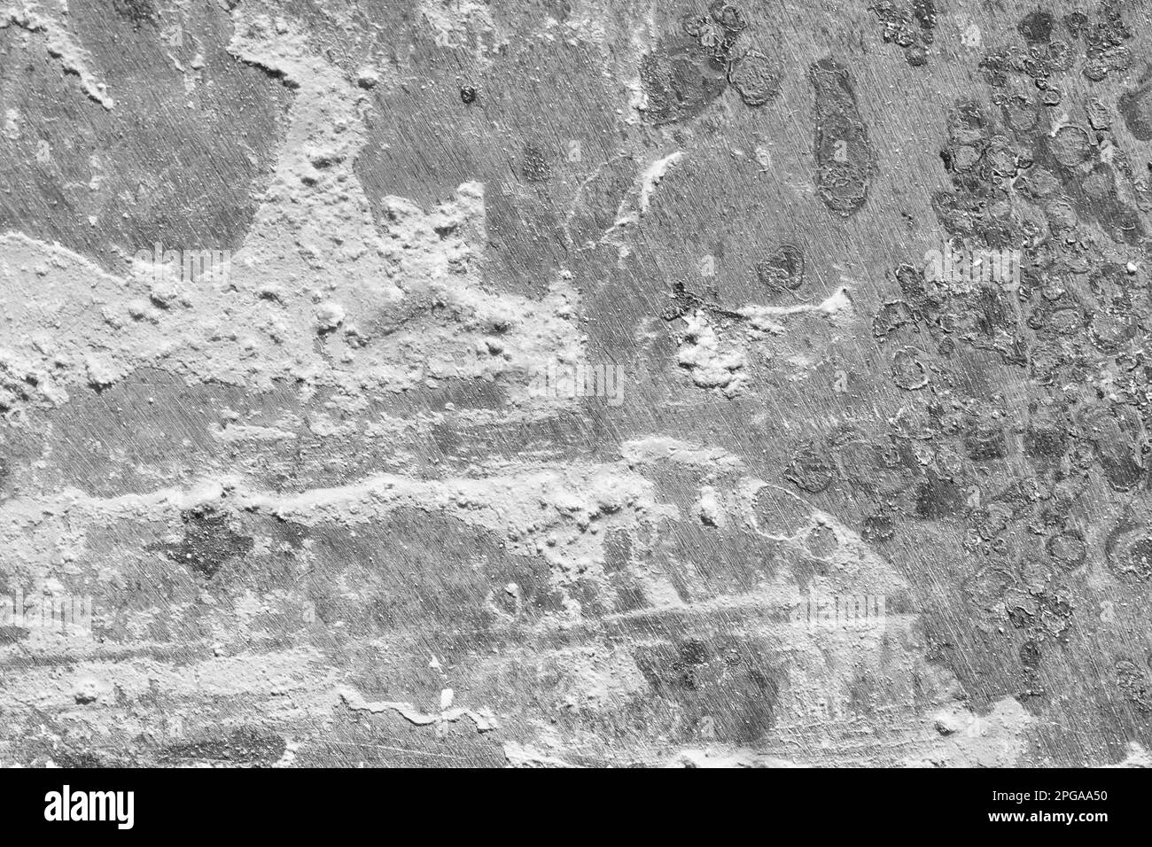 Nahaufnahme von weißer Farbe, Mehl oder anderem Pulver auf der zerkratzten Metalloberfläche. Abstraktes graues Hintergrundbild. Stockfoto