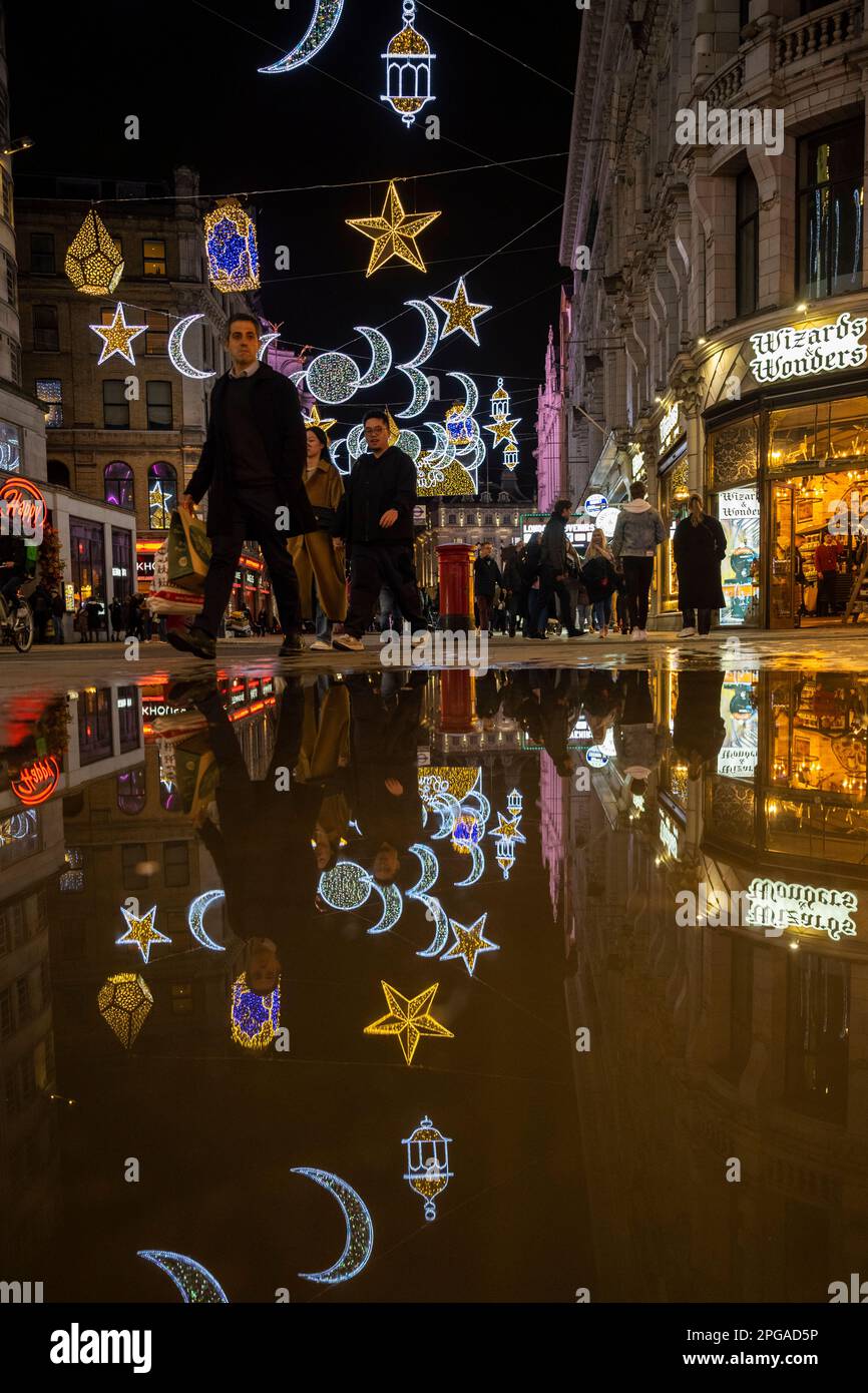 London, Großbritannien. 21. März 2023 Reflexionen der allerersten Ramadan-Lichterinstallation am Piccadilly Circus, die am Vorabend des ersten Ramadan-Tages 2023 eingeschaltet wurden. Lichter dieser Größenordnung sind eine Premiere in Großbritannien und Europa, mit 30.000 nachhaltigen Lichtern, die im Zentrum Londons den ganzen Monat über im Ramadan beleuchtet werden. Kredit: Stephen Chung / Alamy Live News Stockfoto