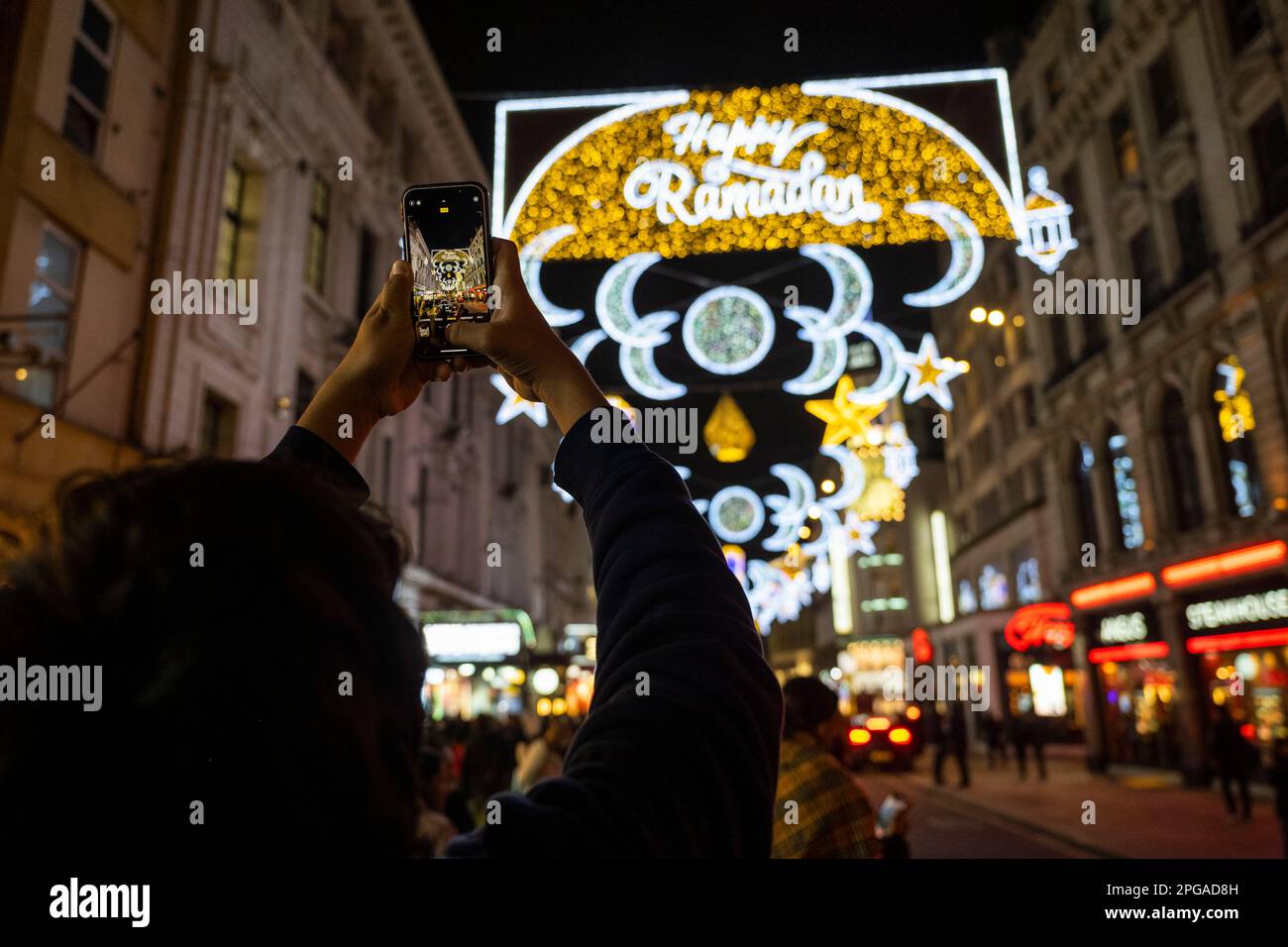 London, Großbritannien. 21. März 2023 Die Öffentlichkeit sieht die erste Ramadan-Lichterinstallation am Piccadilly Circus, die am Vorabend des ersten Tages des Ramadan 2023 eingeschaltet wurde. Lichter dieser Größenordnung sind eine Premiere in Großbritannien und Europa, mit 30.000 nachhaltigen Lichtern, die im Zentrum Londons den ganzen Monat über im Ramadan beleuchtet werden. Kredit: Stephen Chung / Alamy Live News Stockfoto