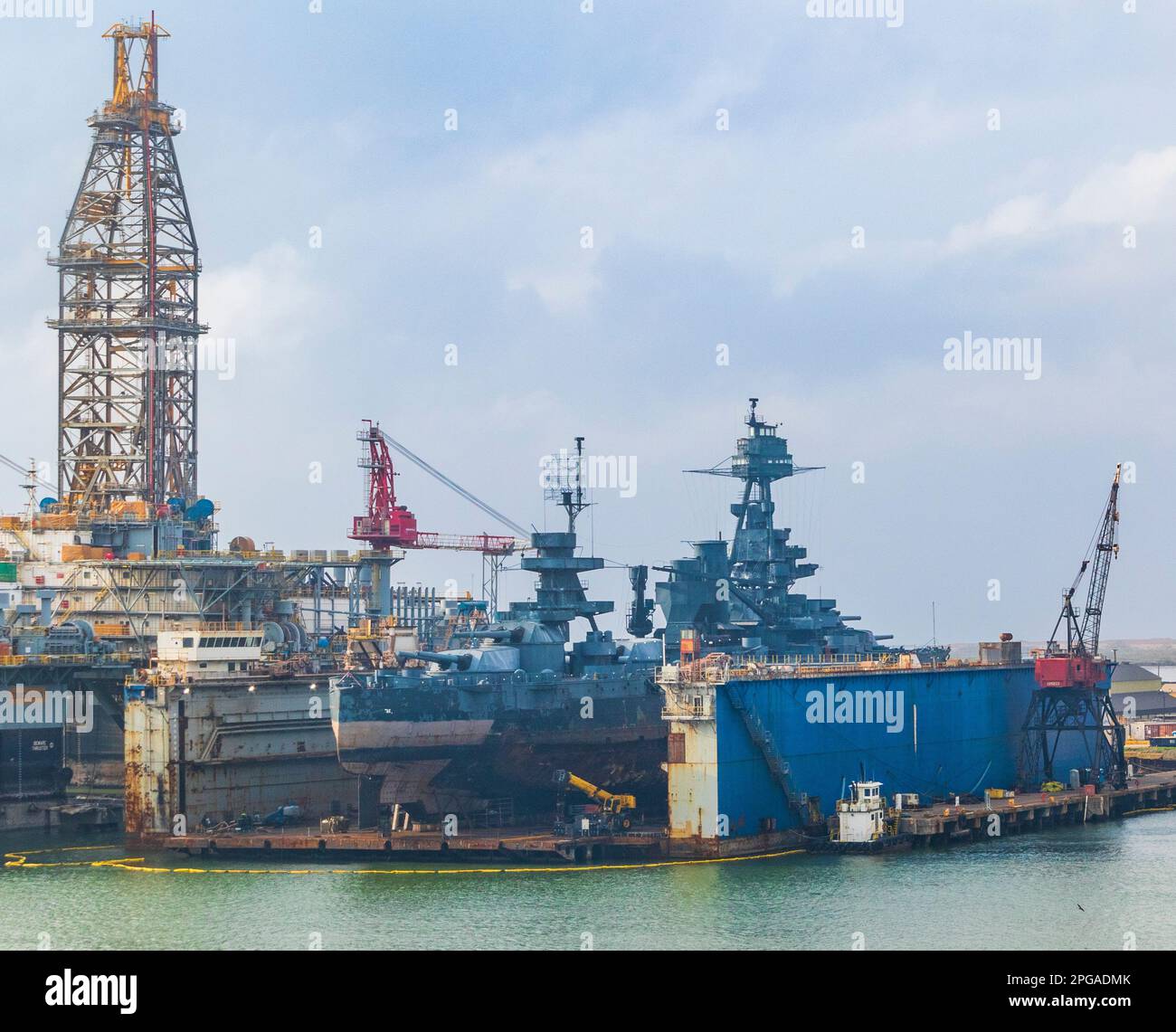 Vom Kreuzfahrtschiff Ruby Princess gesehen, wenn es Galveston verlässt. USS Battleship Texas wird in Galveston Texas repariert. Stockfoto