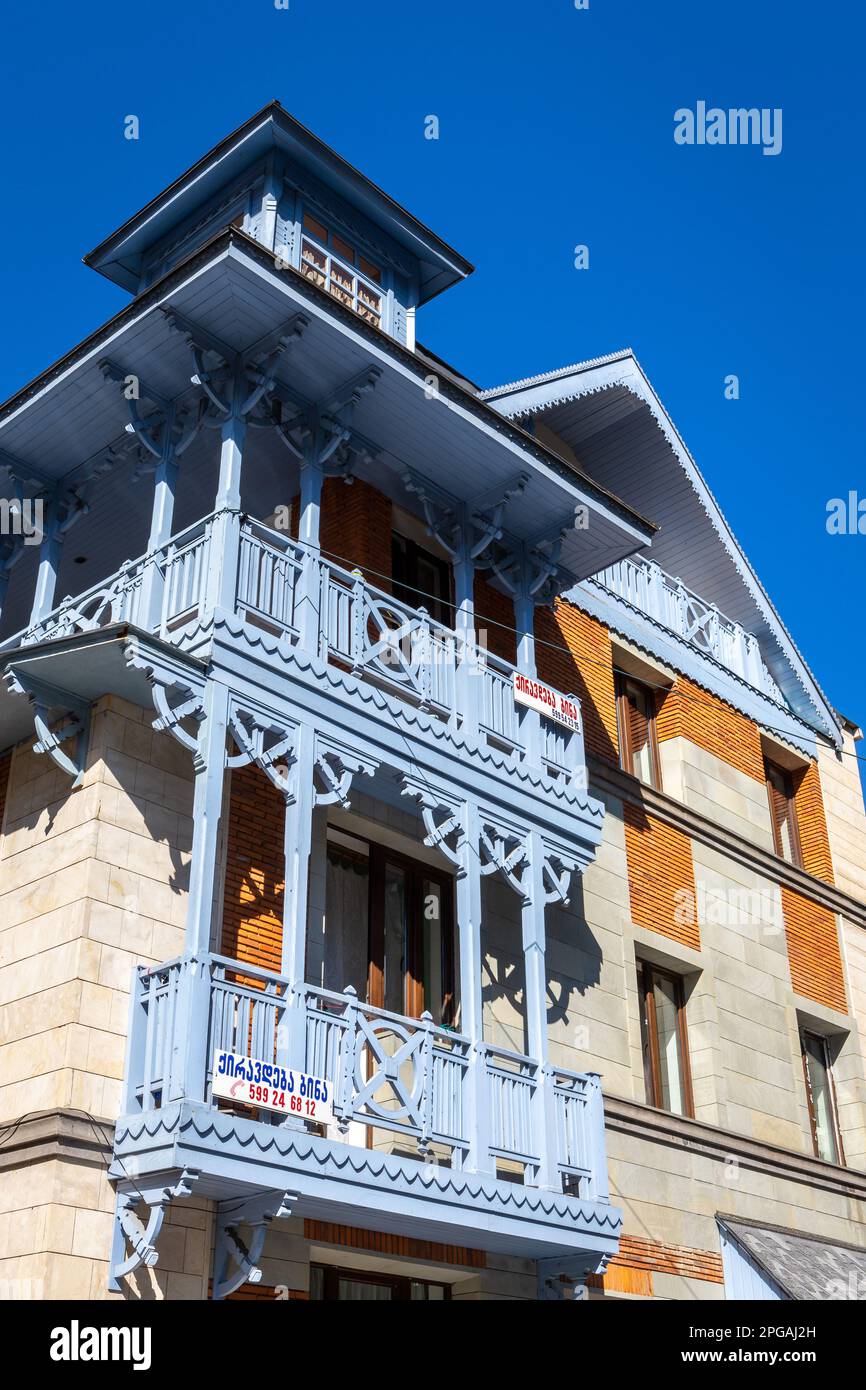 Borjomi, Georgia, 08.06.2021. Traditionelle Borjomi-Gebäudefassade mit blau geschnitztem Holzbalkon im orientalischen Stil. Stockfoto