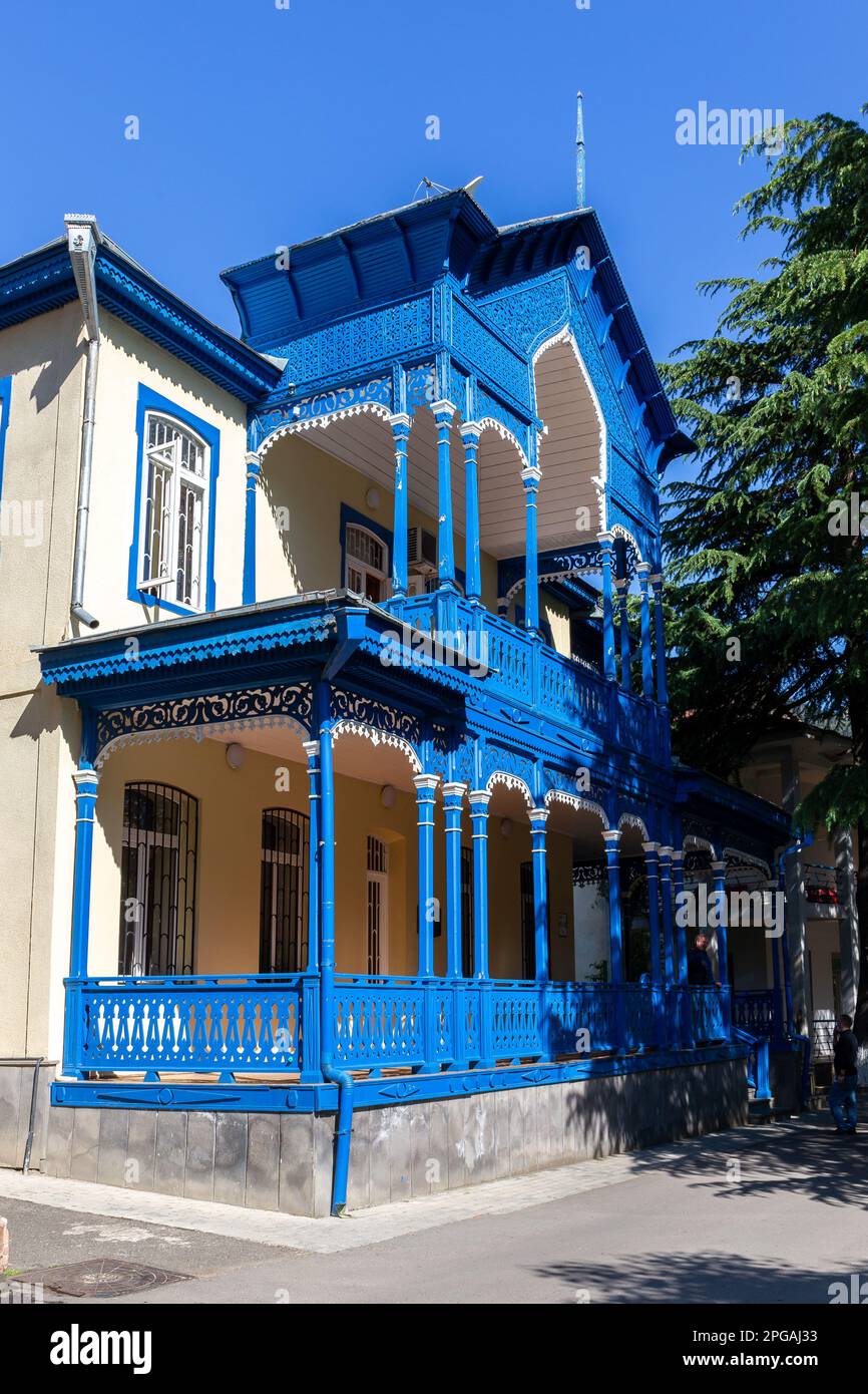 Traditionelle Borjomi-Gebäudefassade mit blau geschnitztem Holzbalkon und Terrasse im orientalischen Stil, Georgia. Stockfoto