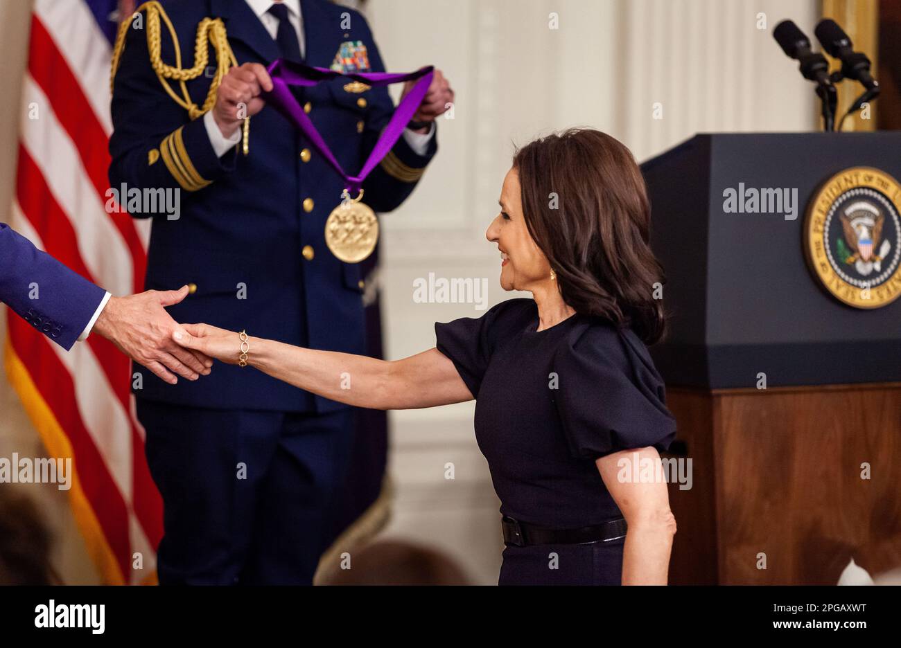 Washington, Usa. 21. März 2023. Julia Louis-Dreyfus ergreift die Hand von Präsident Biden, als sie auf die Bühne kommt, um die Nationale Kunstmedaille zu erhalten. Das Weiße Haus überreichte 23 Personen nationale Medaillen der Künste und nationale Medaillen der Geisteswissenschaften. Die Veranstaltung würdigte die 2021 Medaillenempfänger. Die ursprüngliche Preisverleihung wurde aufgrund der Coronavirus-Pandemie verschoben. Beide Medaillen sind die höchsten Auszeichnungen, die die US-Regierung in Kunst und Geisteswissenschaften verliehen hat. (Foto: Allison Bailey/NurPhoto) Guthaben: NurPhoto SRL/Alamy Live News Stockfoto