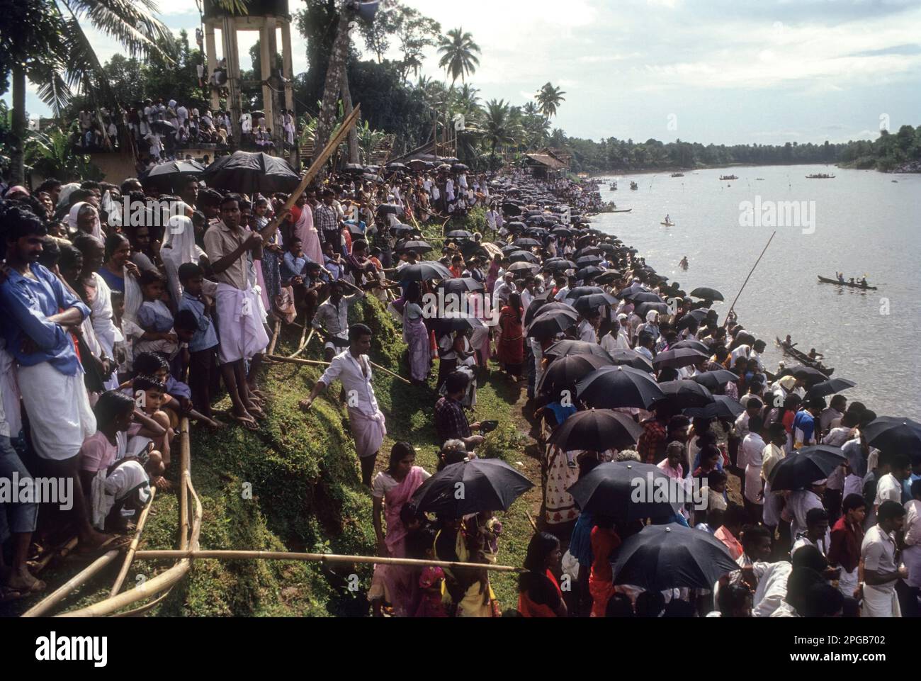 Das Publikum beobachtet das Bootsrennen während des Regens beim Aranmula Vallamkali Festival oder das Snake Boat Race, das während Onam in Aranmula auf dem Pampa River stattfindet Stockfoto