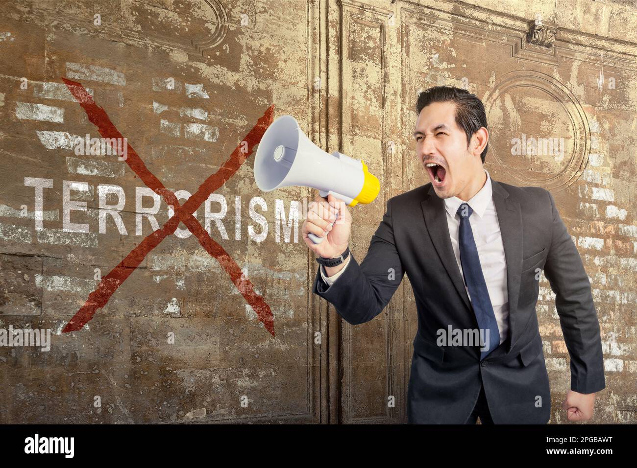 Ein Geschäftsmann, der ein Megafon mit dem Schild "Terror stoppen" an der Wand hält Stockfoto