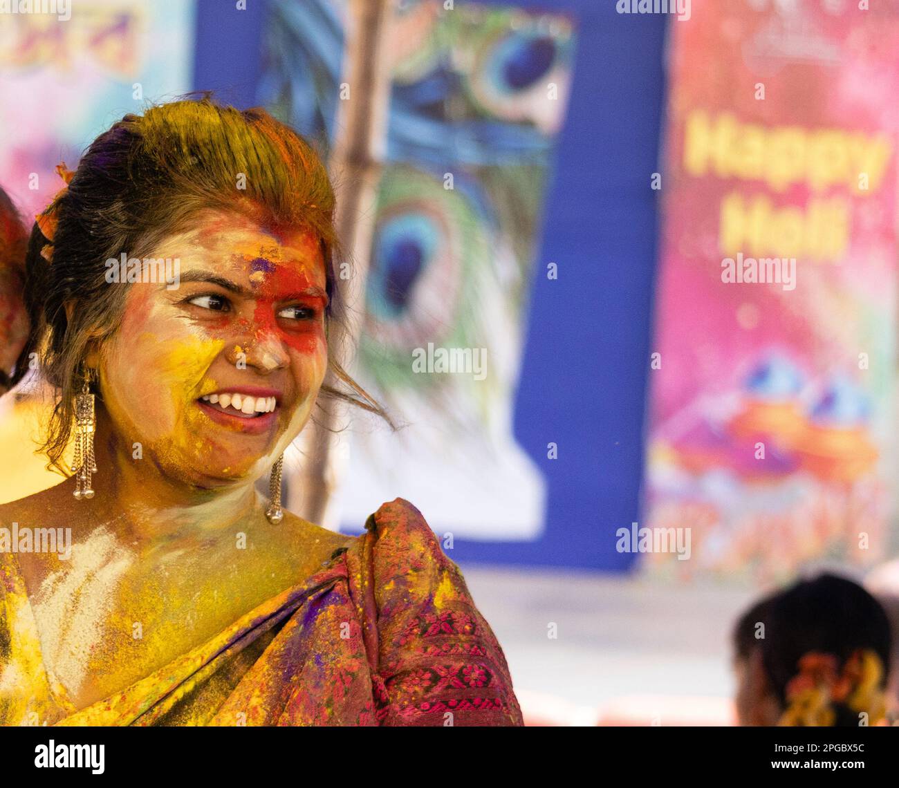 Farbenfrohes lächelndes Gesicht einer indischen Bengalierin in Saree während des holi Festivals Stockfoto