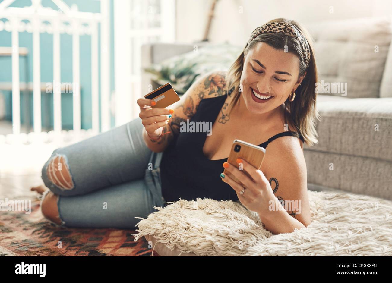 Eine Verabredung zum Mittagessen, nur mit mir. Eine junge Frau, die einen Laptop und eine Kreditkarte in ihrem Wohnzimmer zu Hause benutzt. Stockfoto