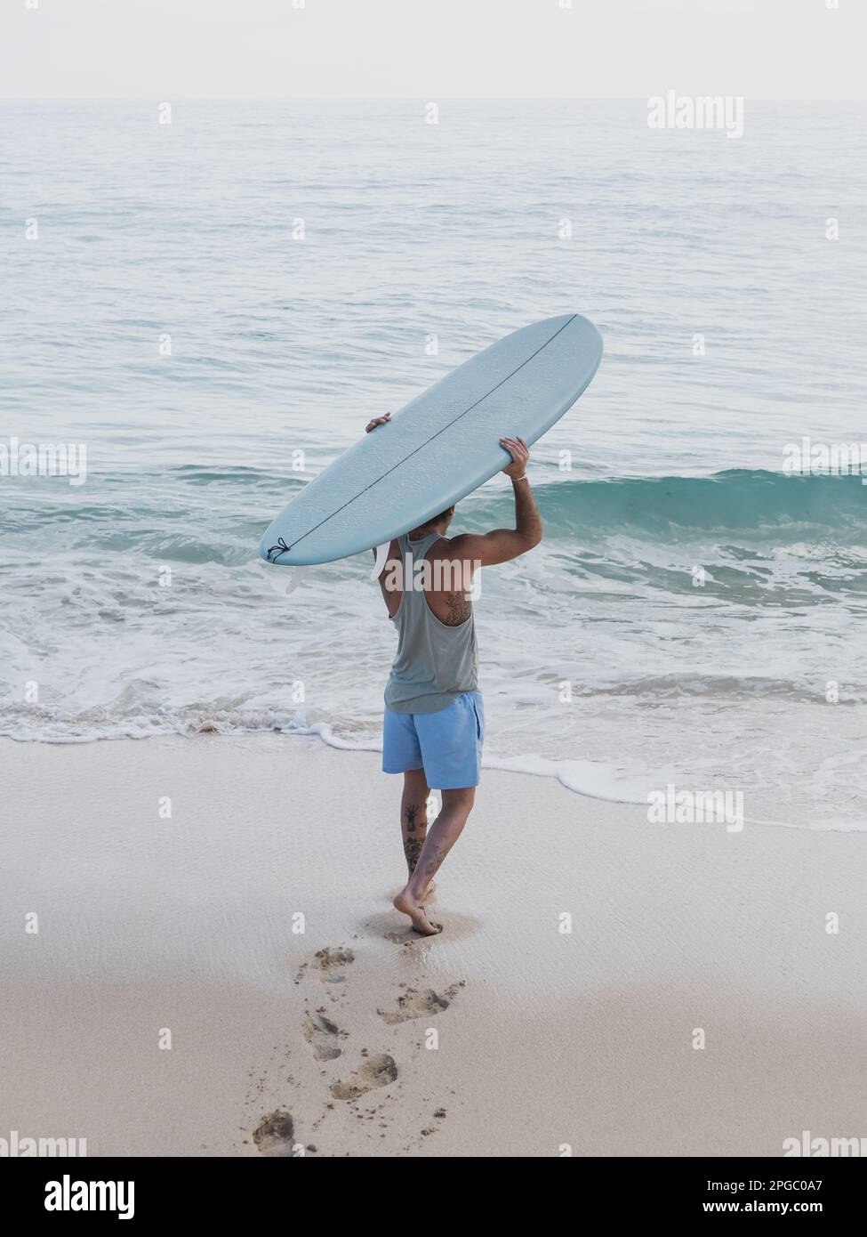 Nicht wiedererkennbarer Surfer von hinten am Strand Stockfoto