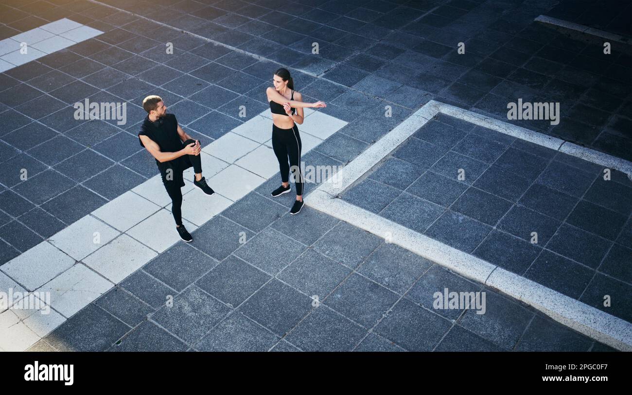 Die Stadt ist ihr Fitnessraum. Ein junges Paar, das sich während seines Trainings in der Stadt dehnt. Stockfoto